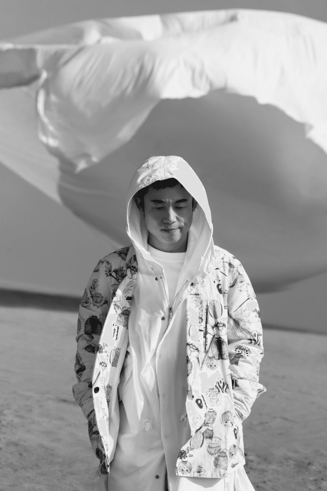 A woman observes framed black-and-white photographs in warm golden light