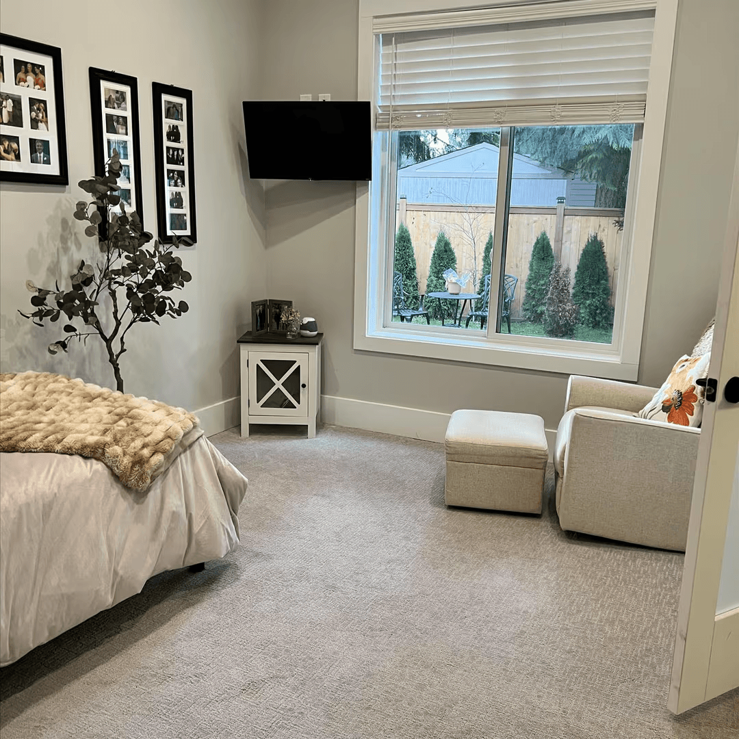 Private resident bedroom in an adult family home with window views of the backyard and natural light.