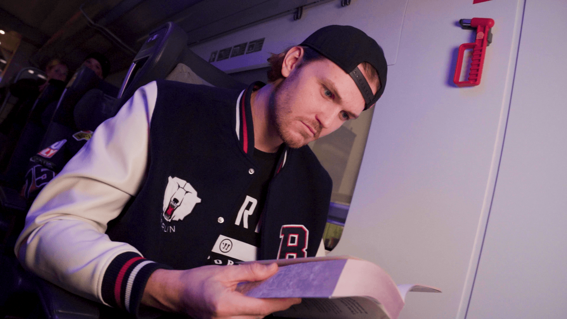 Ice hockey Eisbaeren Berlin player reading book in deutsche bahn music video