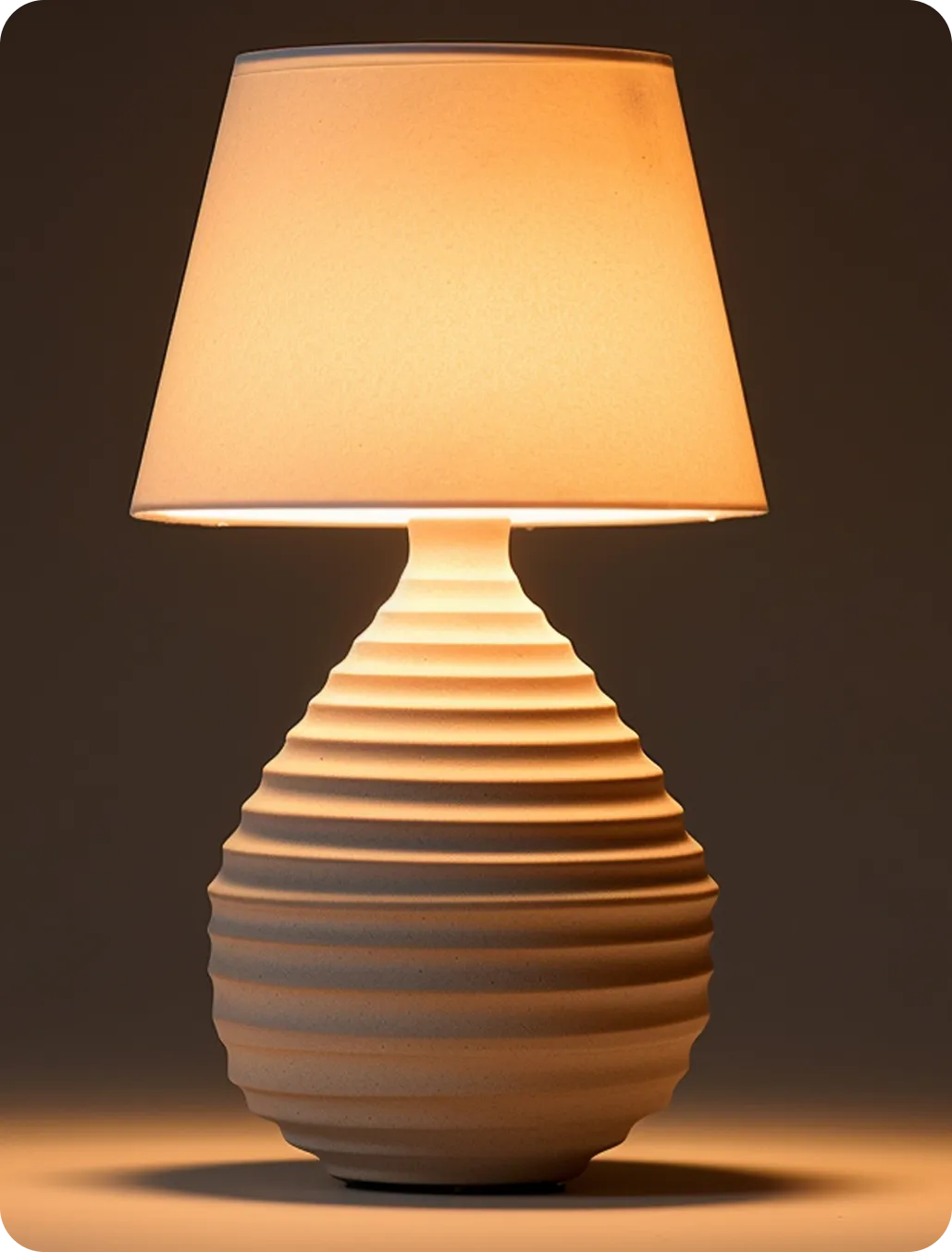 Small table lamp glowing with warm amber light against a dark background.
