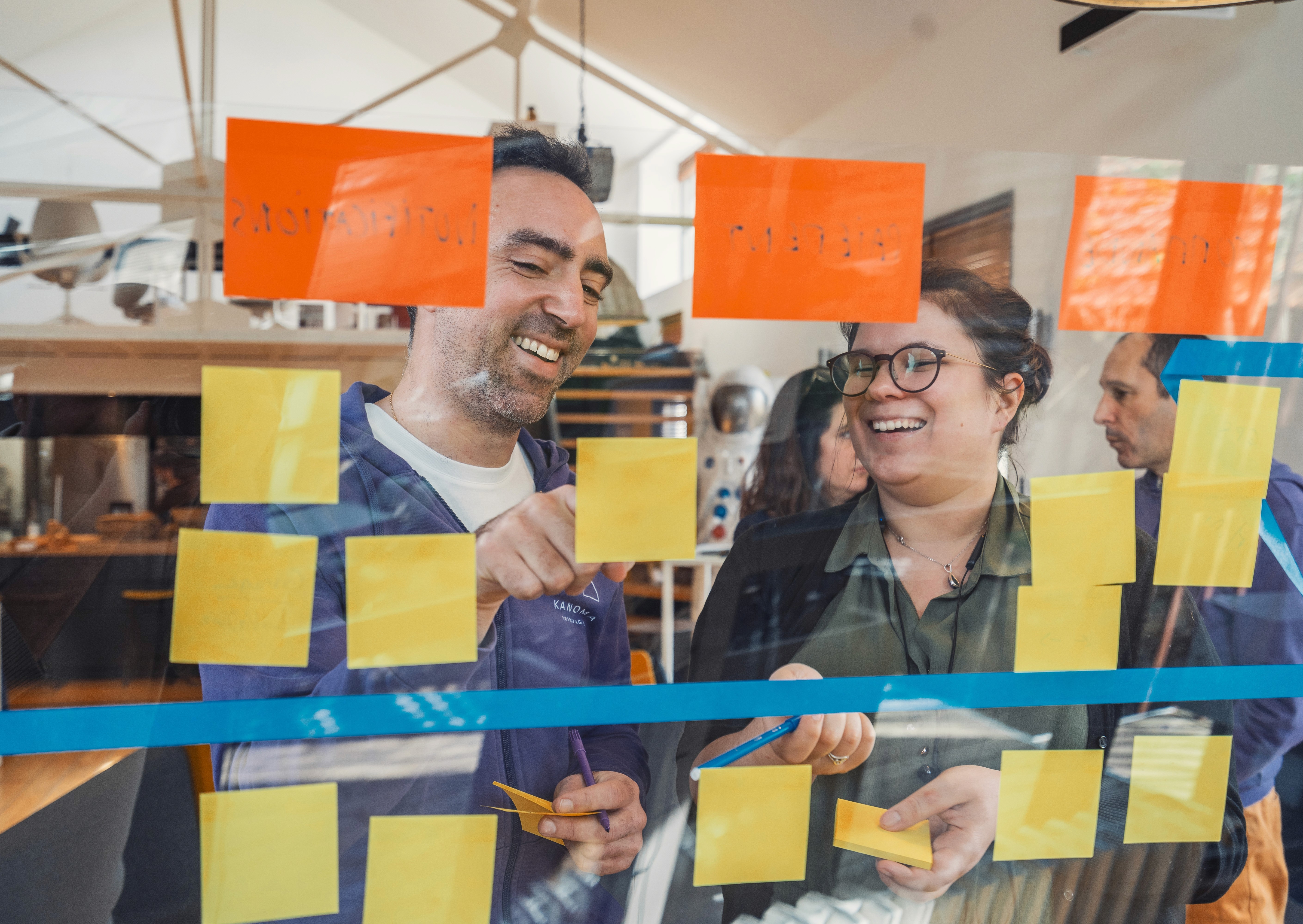 deux personnes en train de discuter devant leur ordinateur