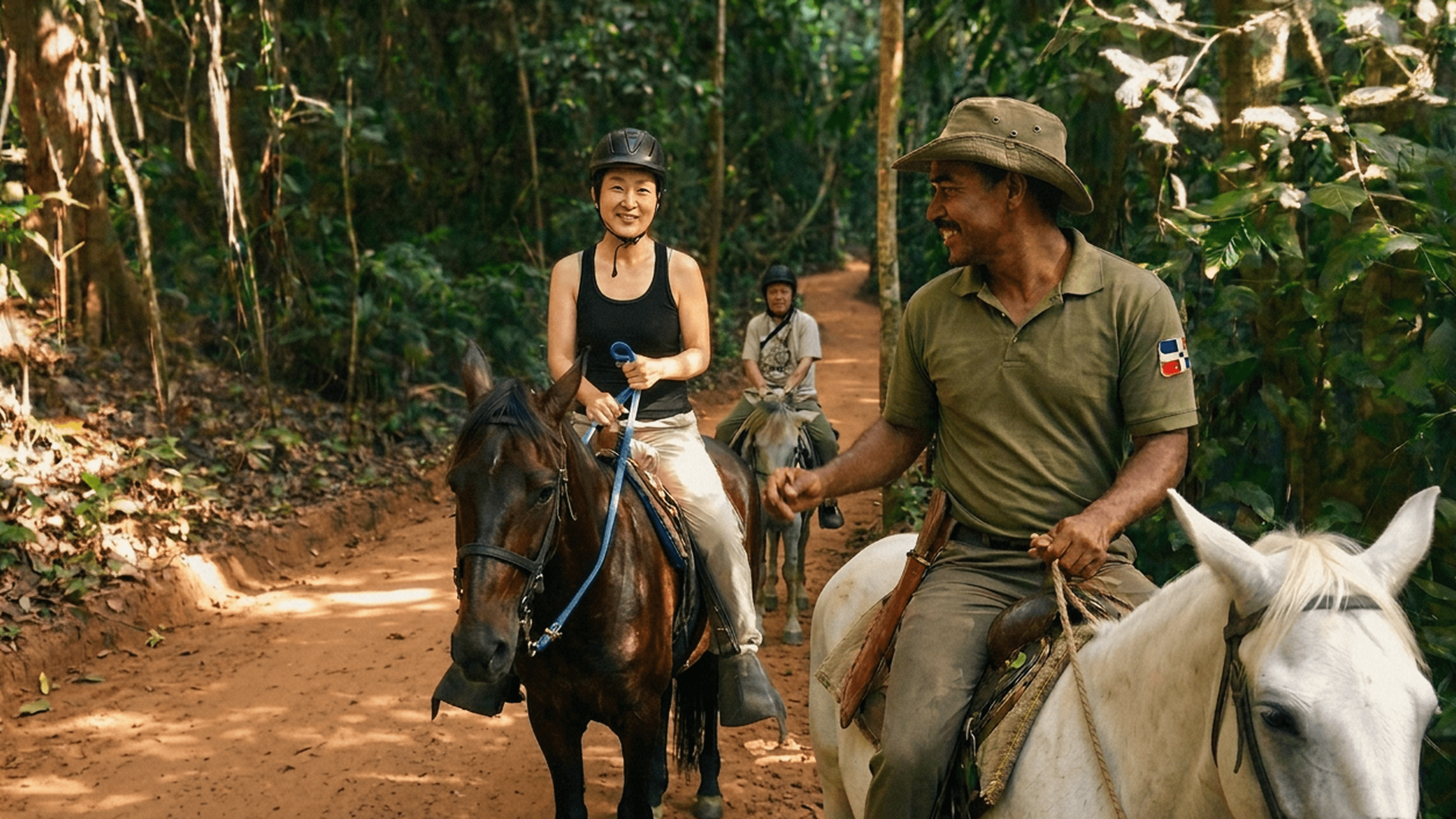 Smiling people on horseback on a jungle trail.