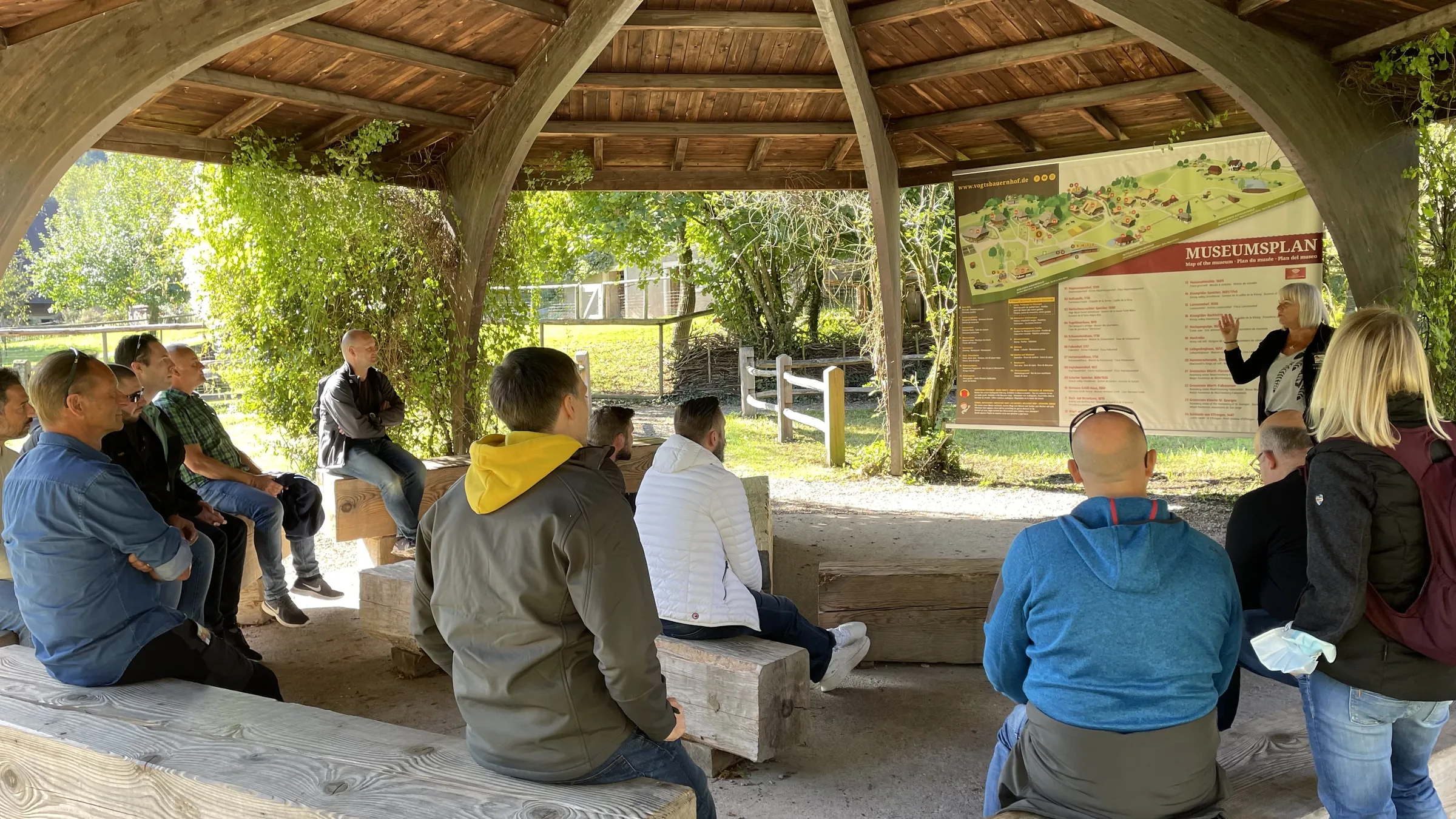 Das trimaster-Team bei einer Präsentation in einem Holzpavillon im Freien
