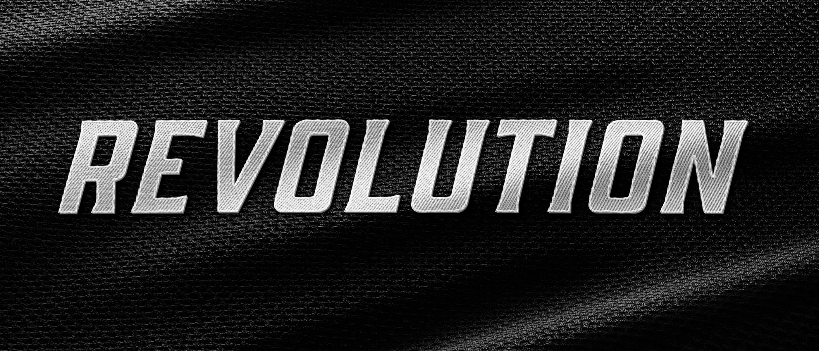 Metallic textured Revolution Athletics wordmark on a black mesh fabric background.