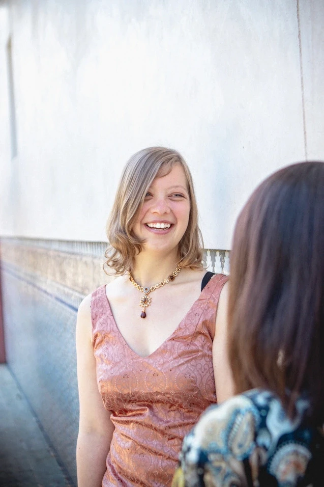 Woman laughing, looking happy and positive while talking with someone.