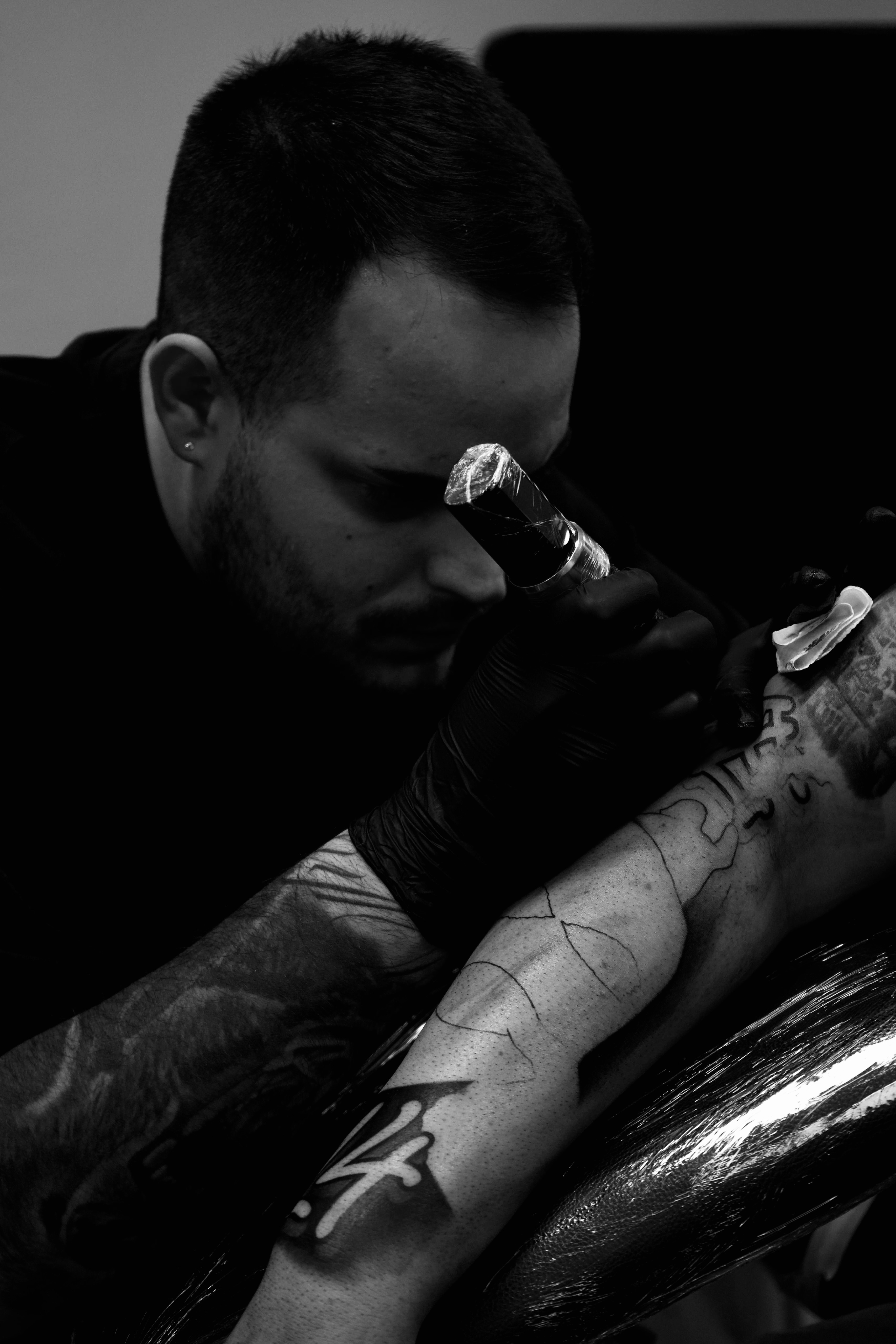 uomo che tatua un avambraccio