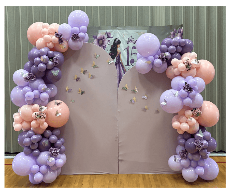 Balloon arch with big 15 inch balloons and 7 inch ballloons in the colours black, purple and blue. The arch is black and has happy birthday sign. The theme is based out of fortnite video game.