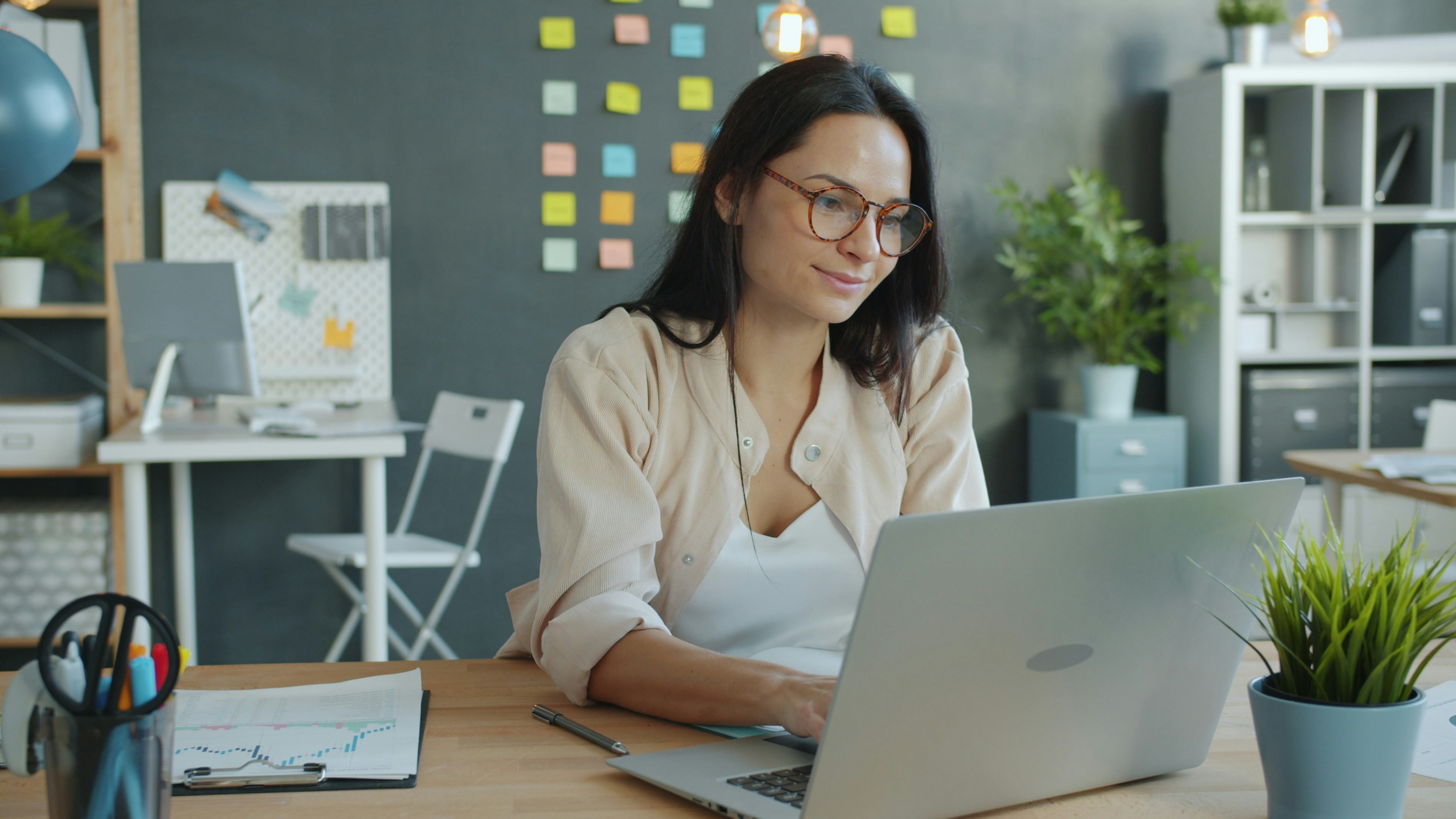 Woman working on a laptop in a modern office.