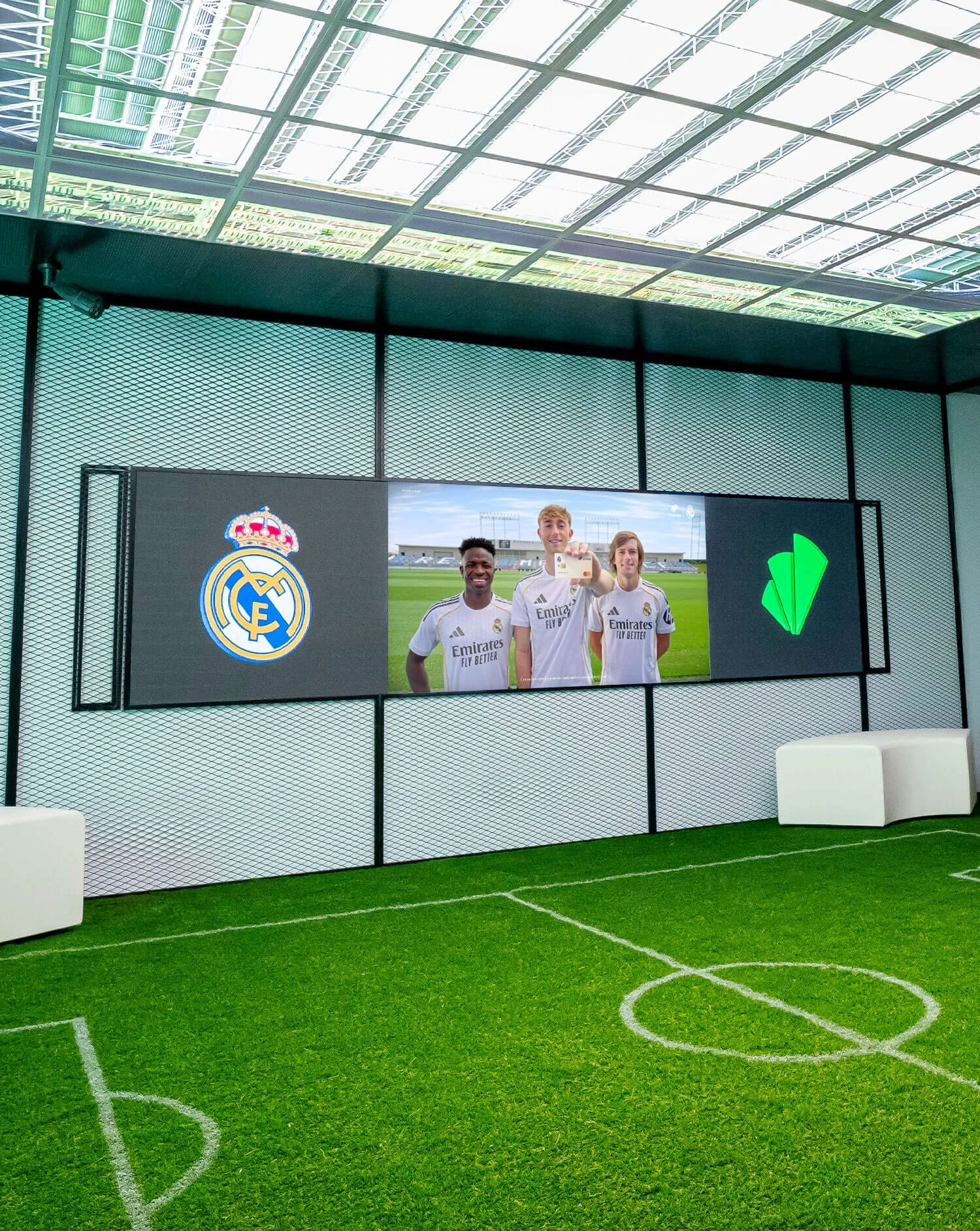 Espacio de activación de Unicaja decorado como un campo de fútbol con pantalla central mostrando la creatividad 'Todo empieza cuando te atreves'.