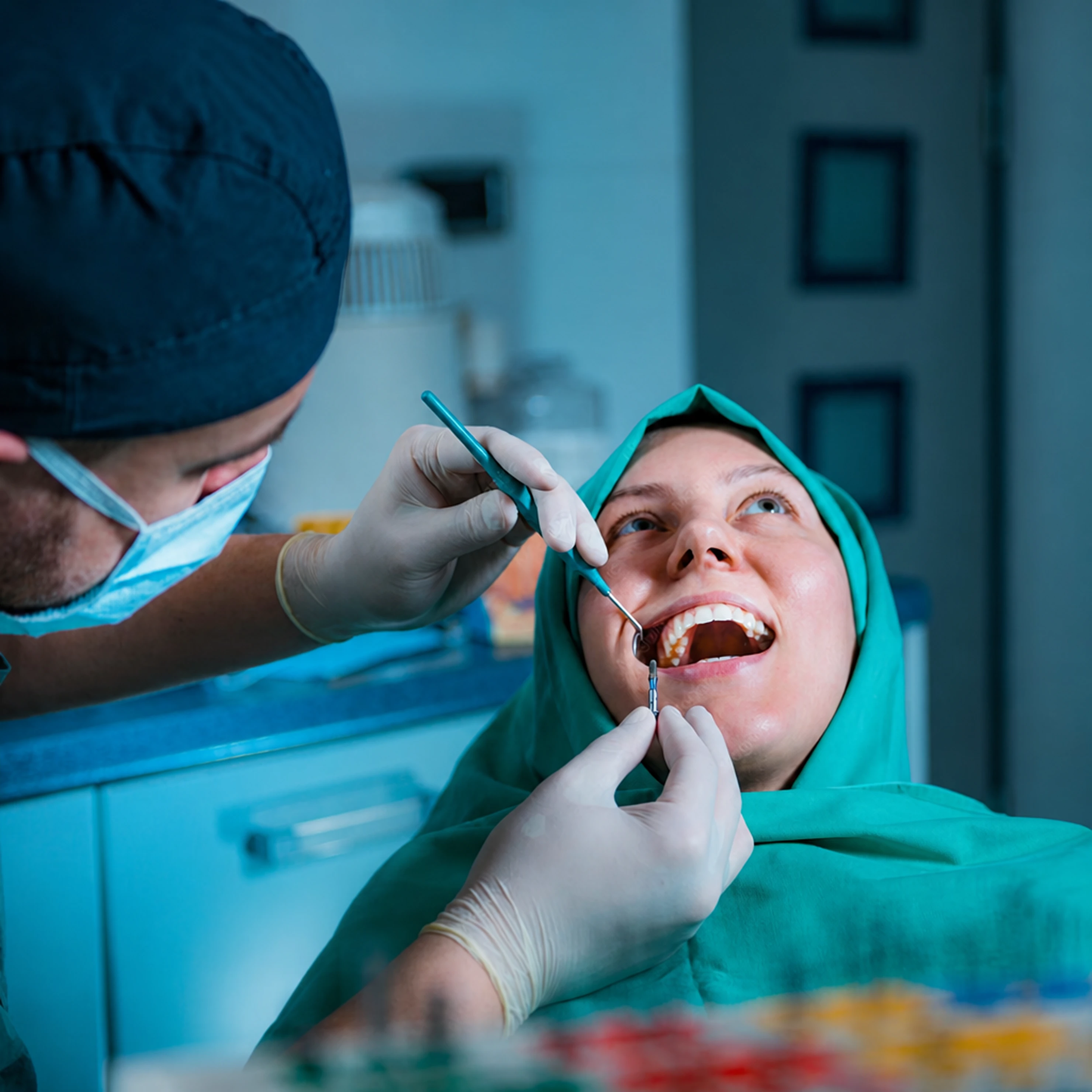 Dentist and assistant treating a patient in a dental chair.
