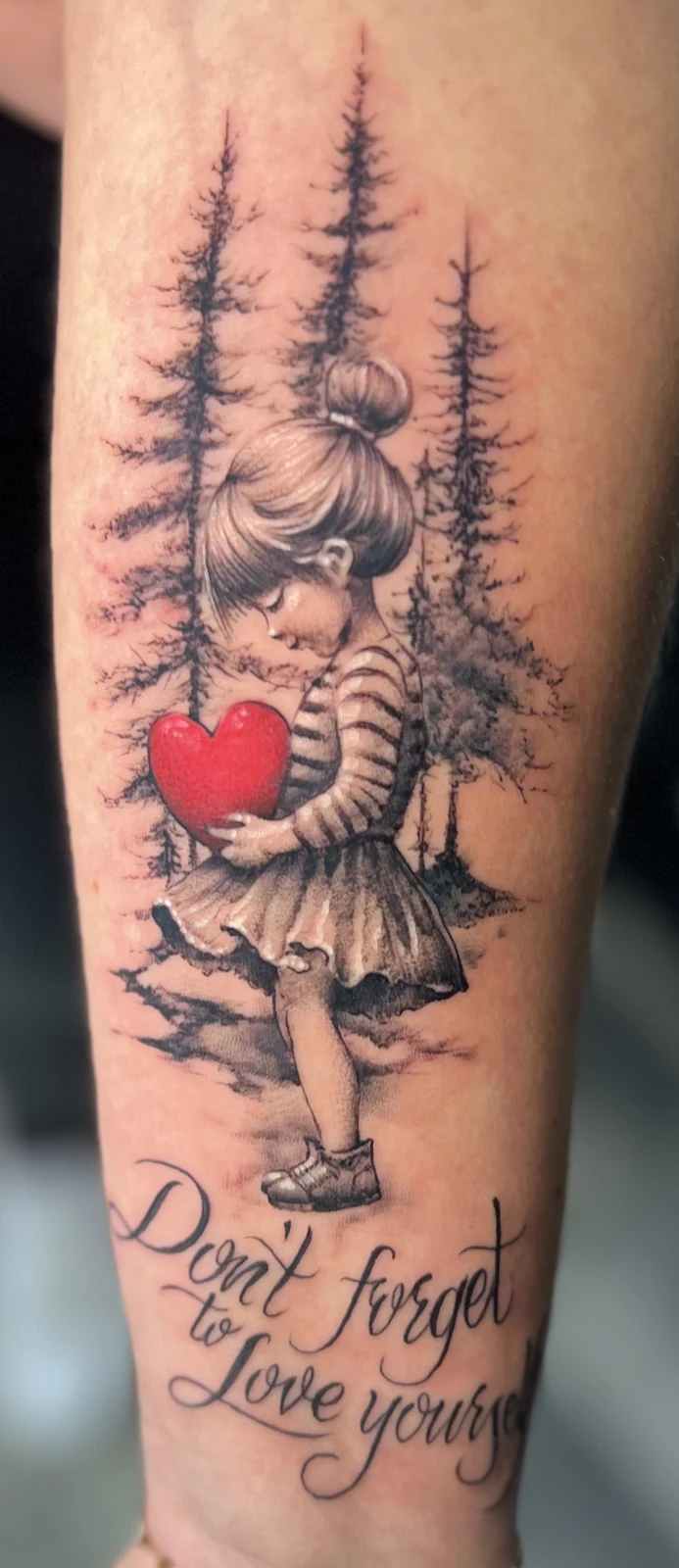 Girl with a red heart and lettering forearm tattoo by Tomski