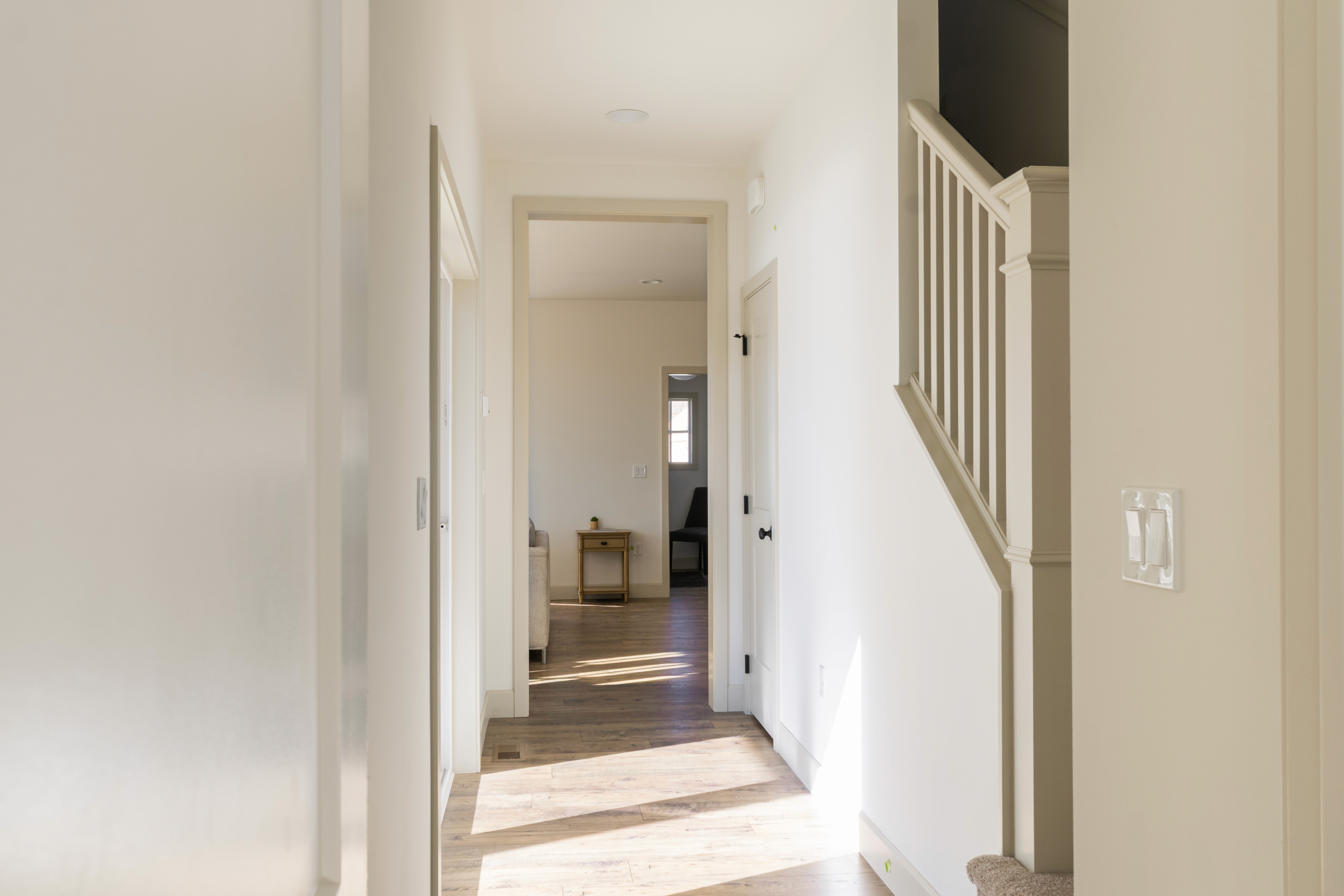 Hallway with staircase to second level and door to patio.
