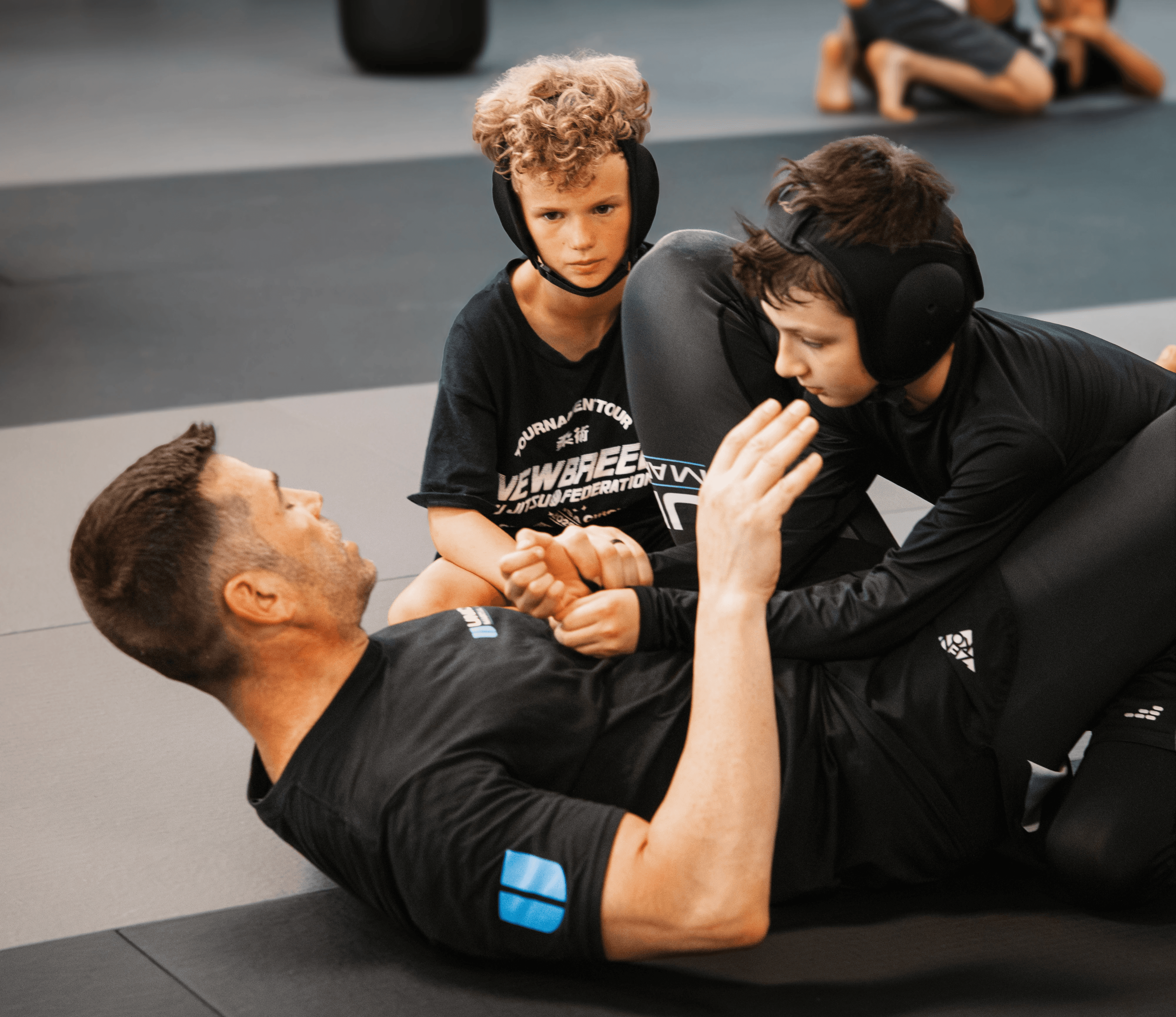 Coach Nolan on the mat with students at Union Martial Arts