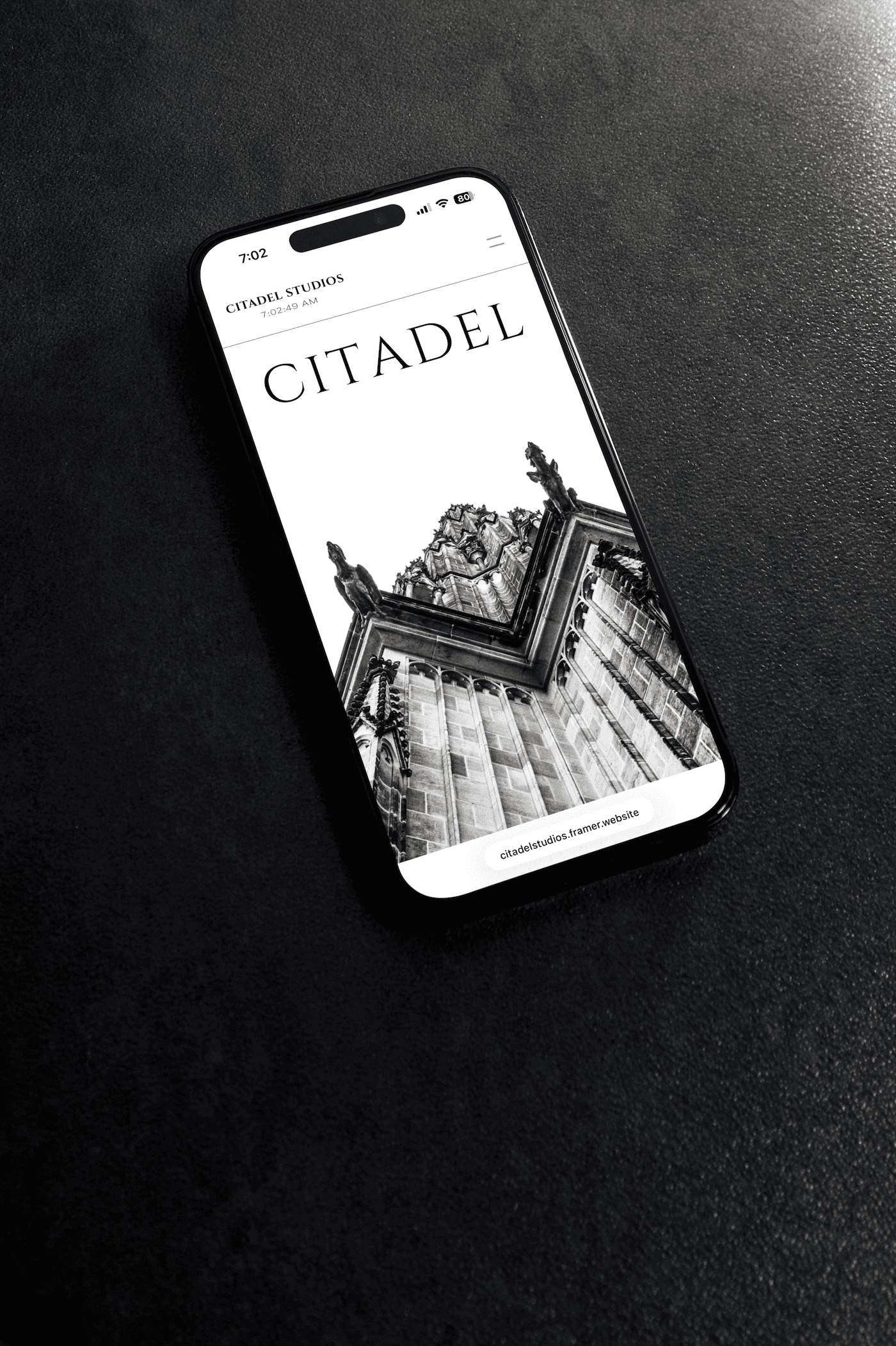 phone with website on screen laying on black background