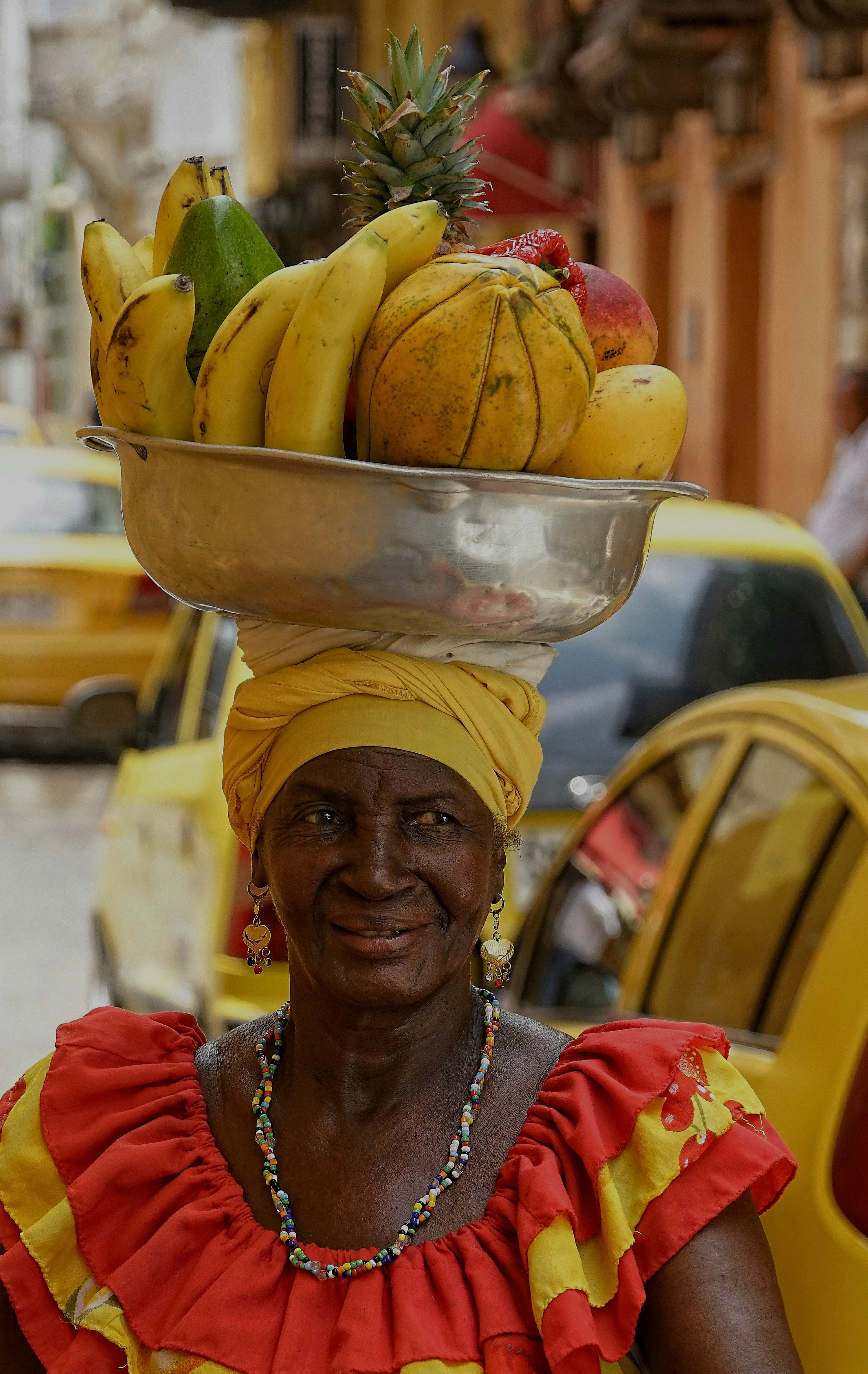 woman carrying fruits in a bowl