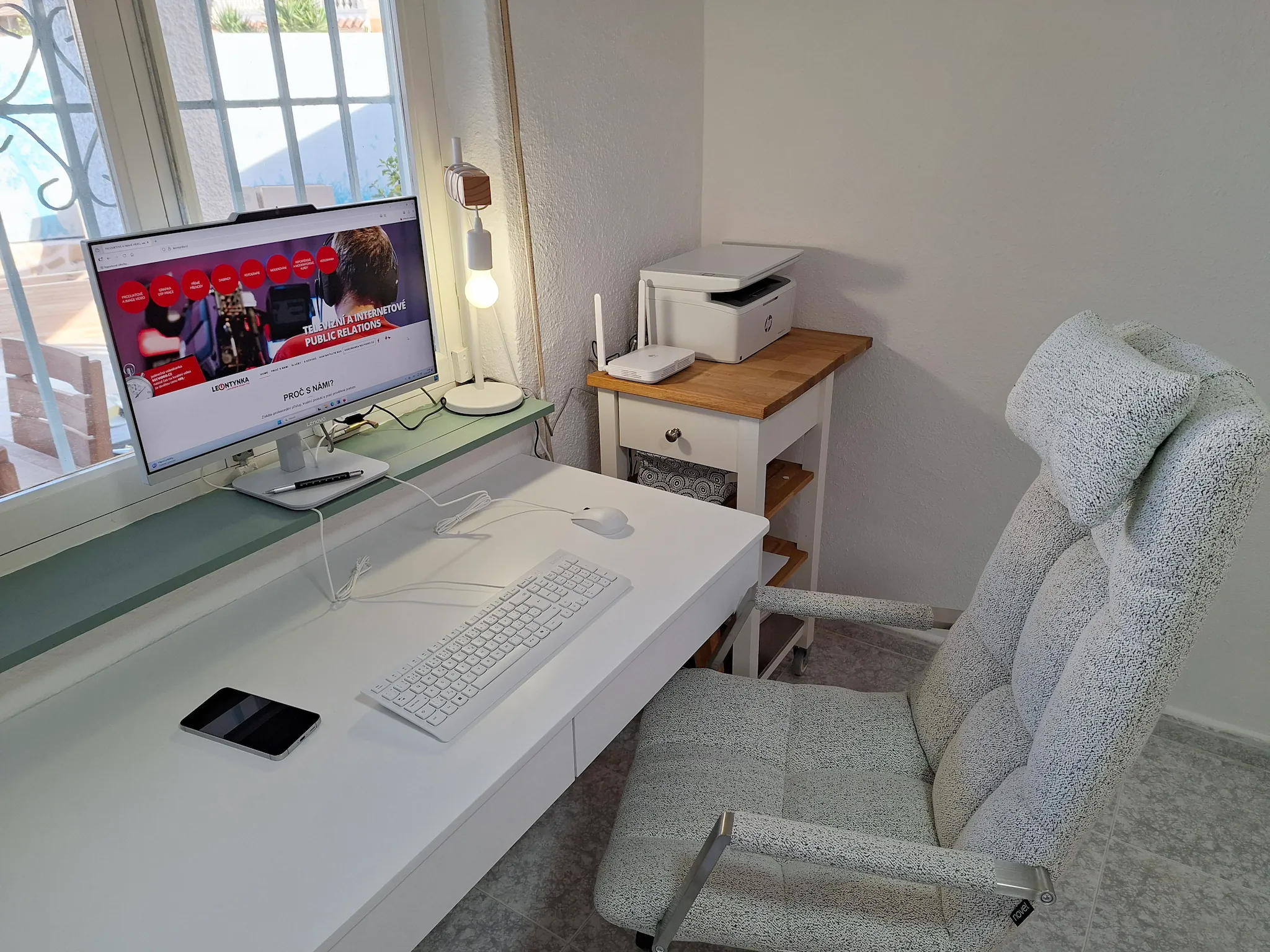 Minimalist living space with low modern furniture, large floor-to-ceiling windows, soft natural light, and an open view of a calm outdoor landscape.