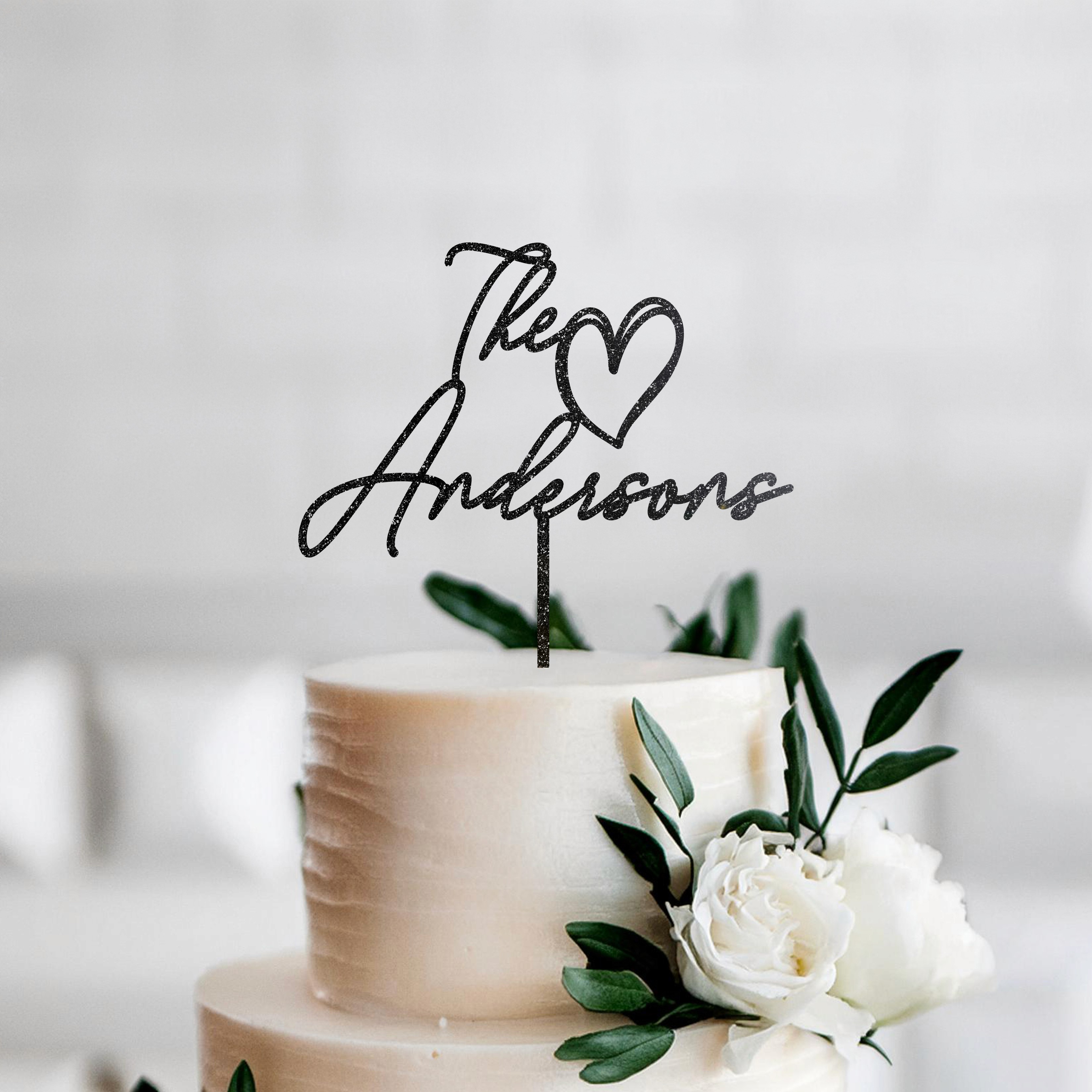 Personalized cake topper for weddings with The Andersons and a heart design in Black glitter. Ideal for adding a romantic and elegant touch to your wedding cake. Handcrafted and available in multiple colors.