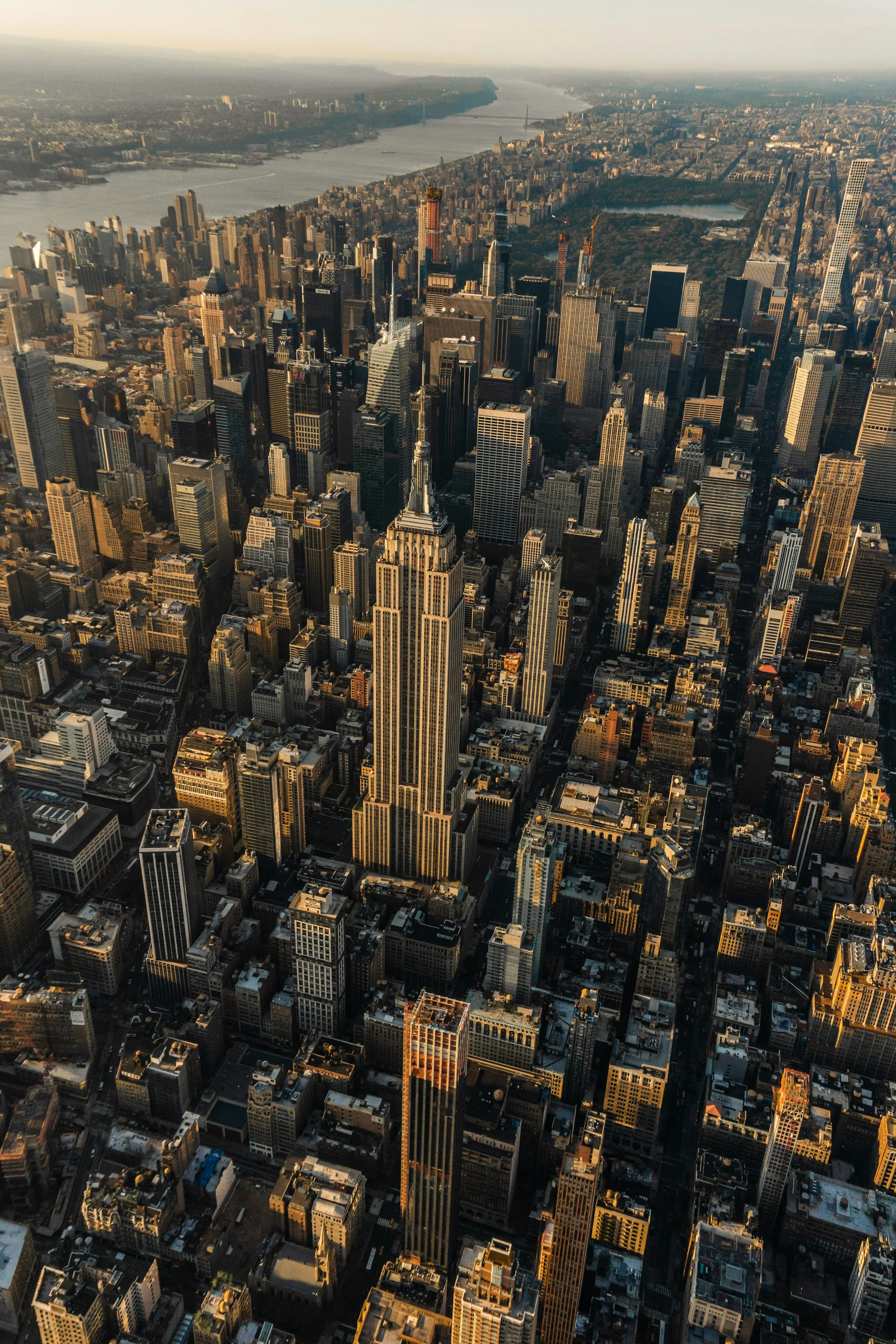 Aerial view of Manhattan's Empire State Building and skyscrapers at sunrise.