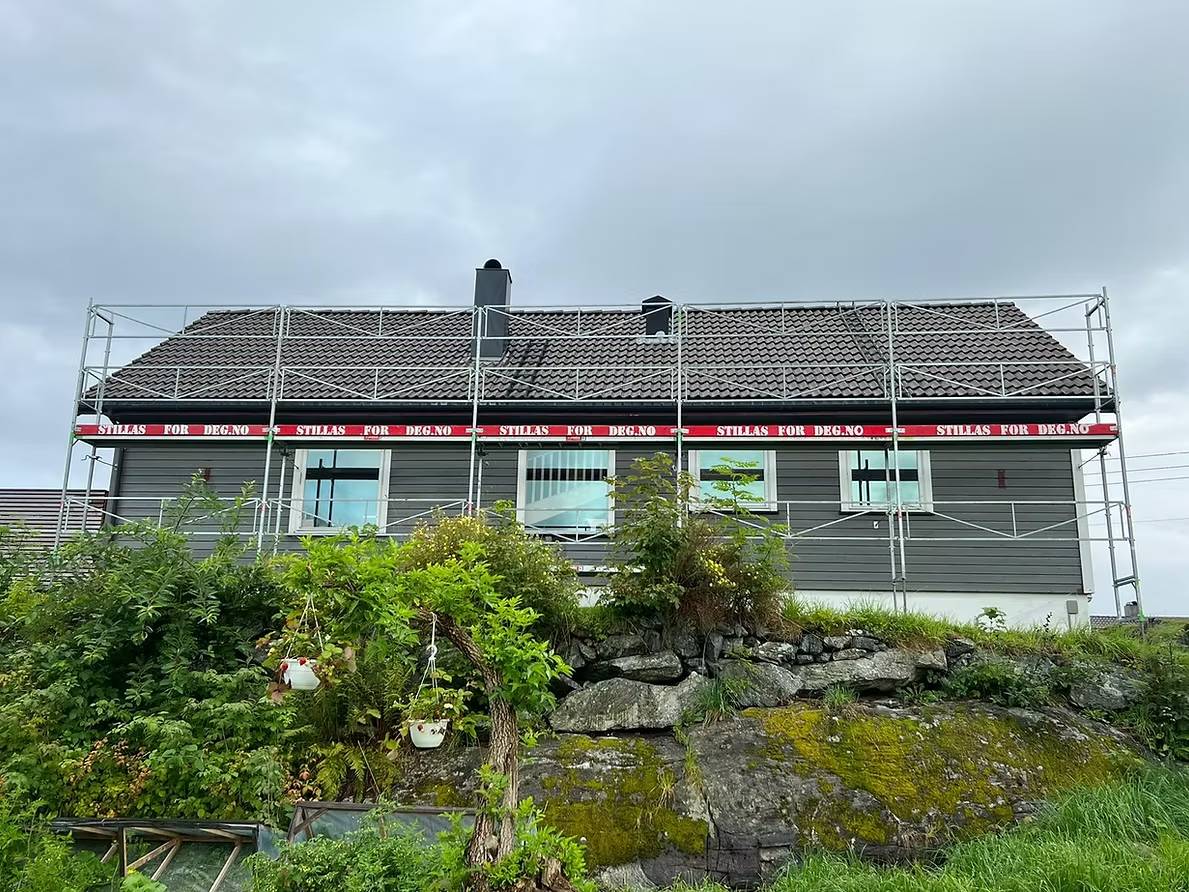 woman in blue jacket and blue denim jeans standing on brown wooden bridge