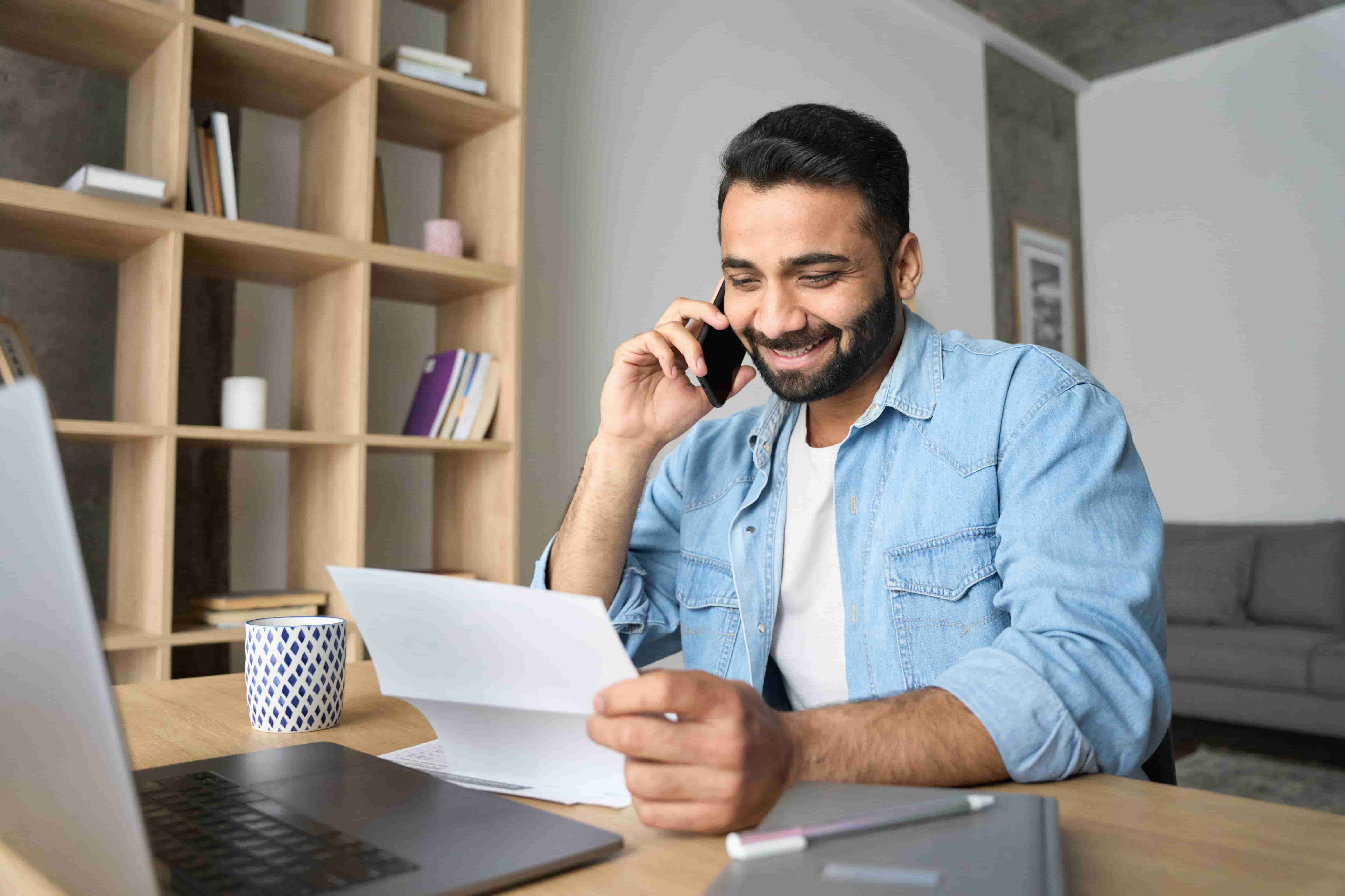 Business man holding paper and talking on phone