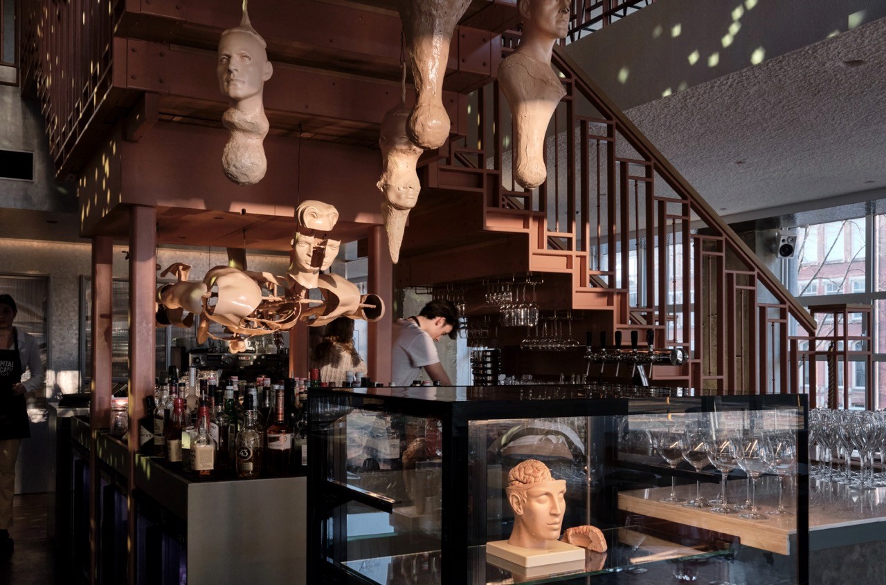 The modern staircase at Capital Kitchen Amsterdam, with warm pendant lighting and natural wood details.
