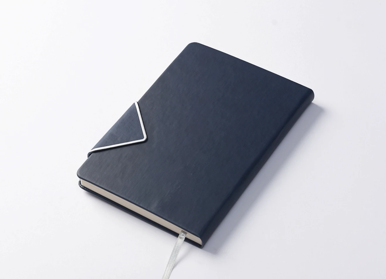 Navy blue journal with envelope-style strap closure on a white background