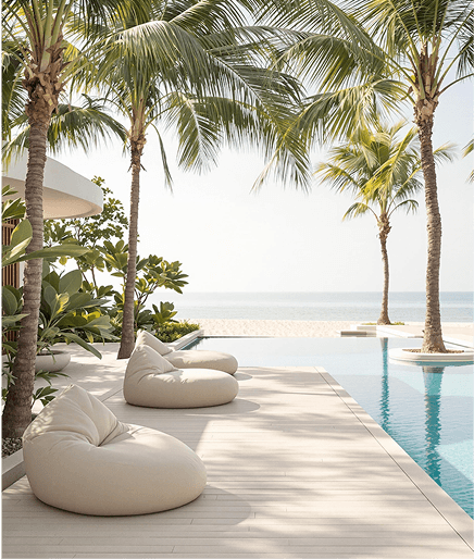Luxurious beach cabanas with white curtains and loungers facing a clear blue ocean.