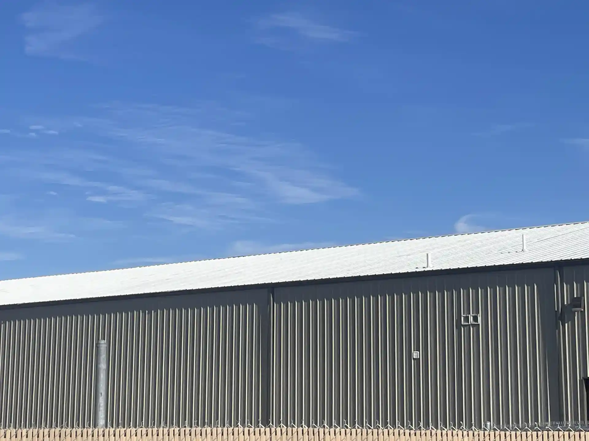 Un toit en pente d'un bâtiment commercial recouvert d'un revêtement acrylique blanc Rub-R-Roof