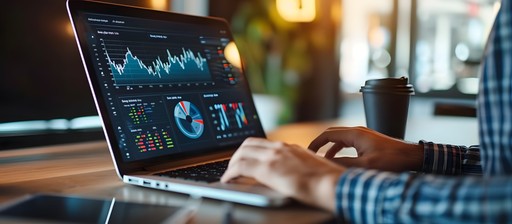 Person analyzing financial and performance data on a laptop, with multiple charts and graphs displayed on the screen, representing data-driven insights and analytics.