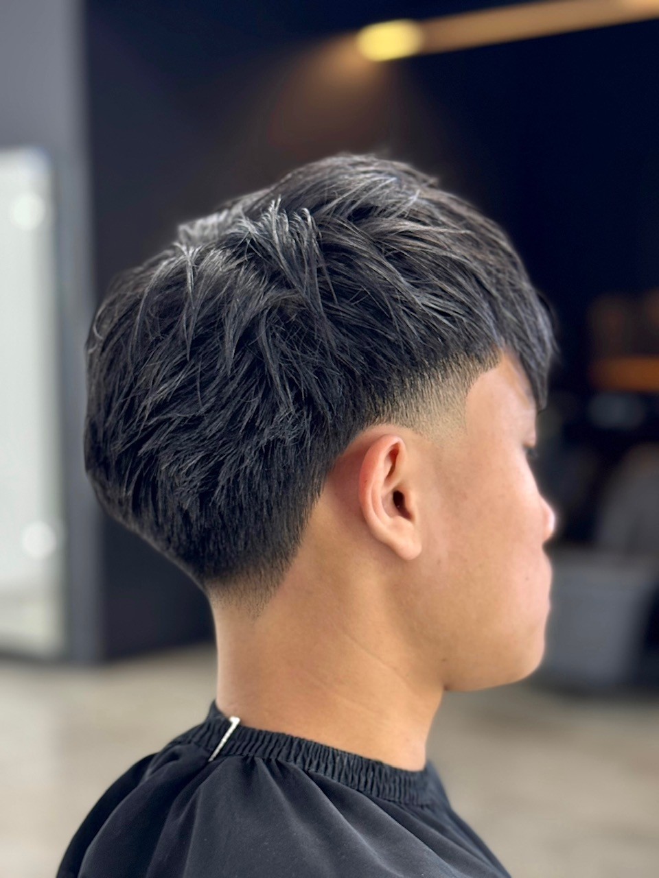 Mid Taper Fade haircut featuring thick Asian hair and a polished finish by Courtney Palmore, perfect for low maintenance men’s styling. The Rich Barber Hair Studio West Hollywood, California. Los Angeles