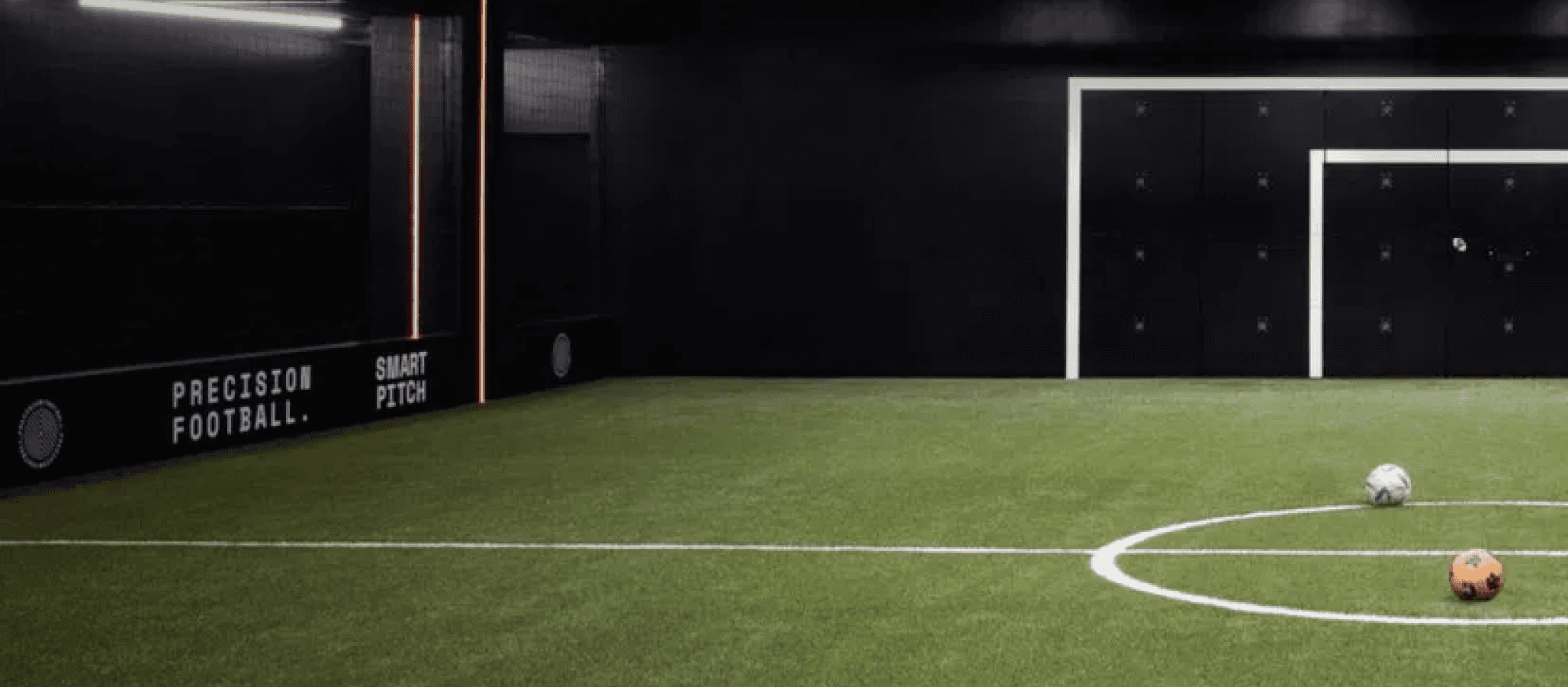 football field with footballs on the pitch