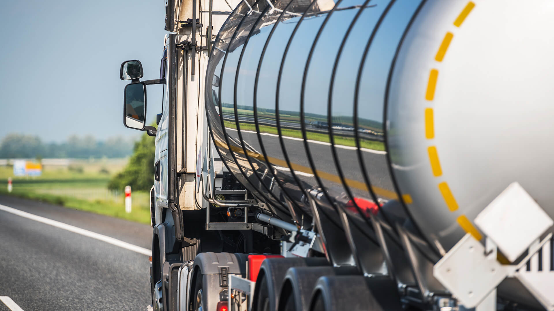 high resolution photo of the rear side view of a fuel transport truck driving along the highway