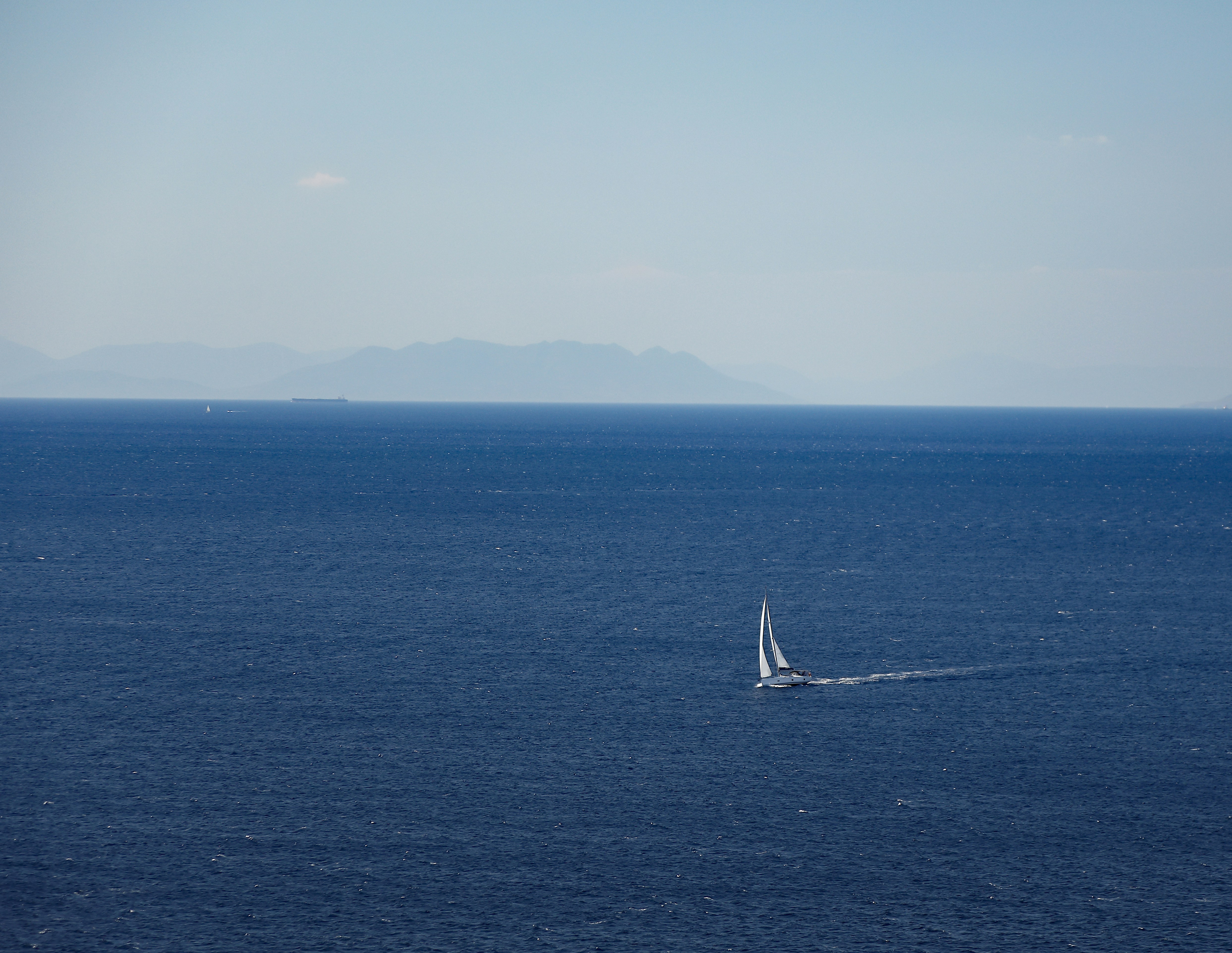 a sailboat in the middle of the ocean