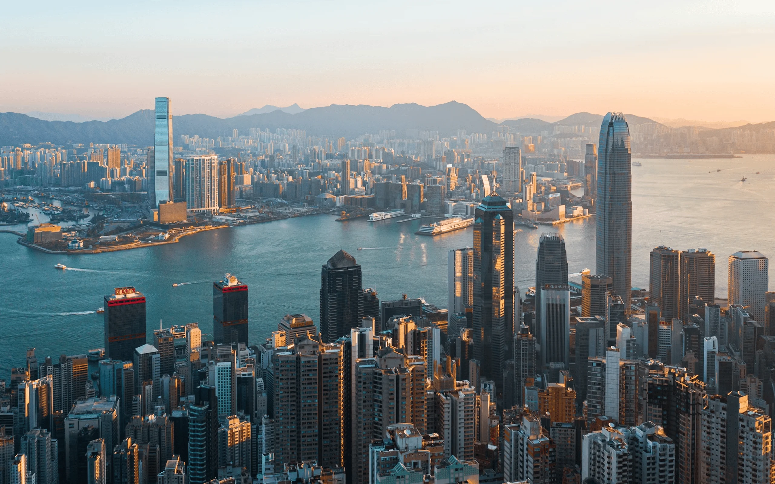 Aerial view of Hong Kong’s skyline and Victoria Harbour at sunset.