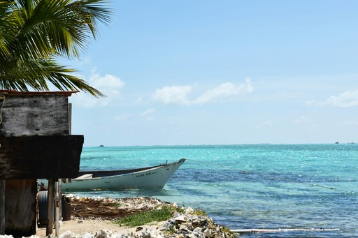 a boat sitting on top of a beach next to the ocean