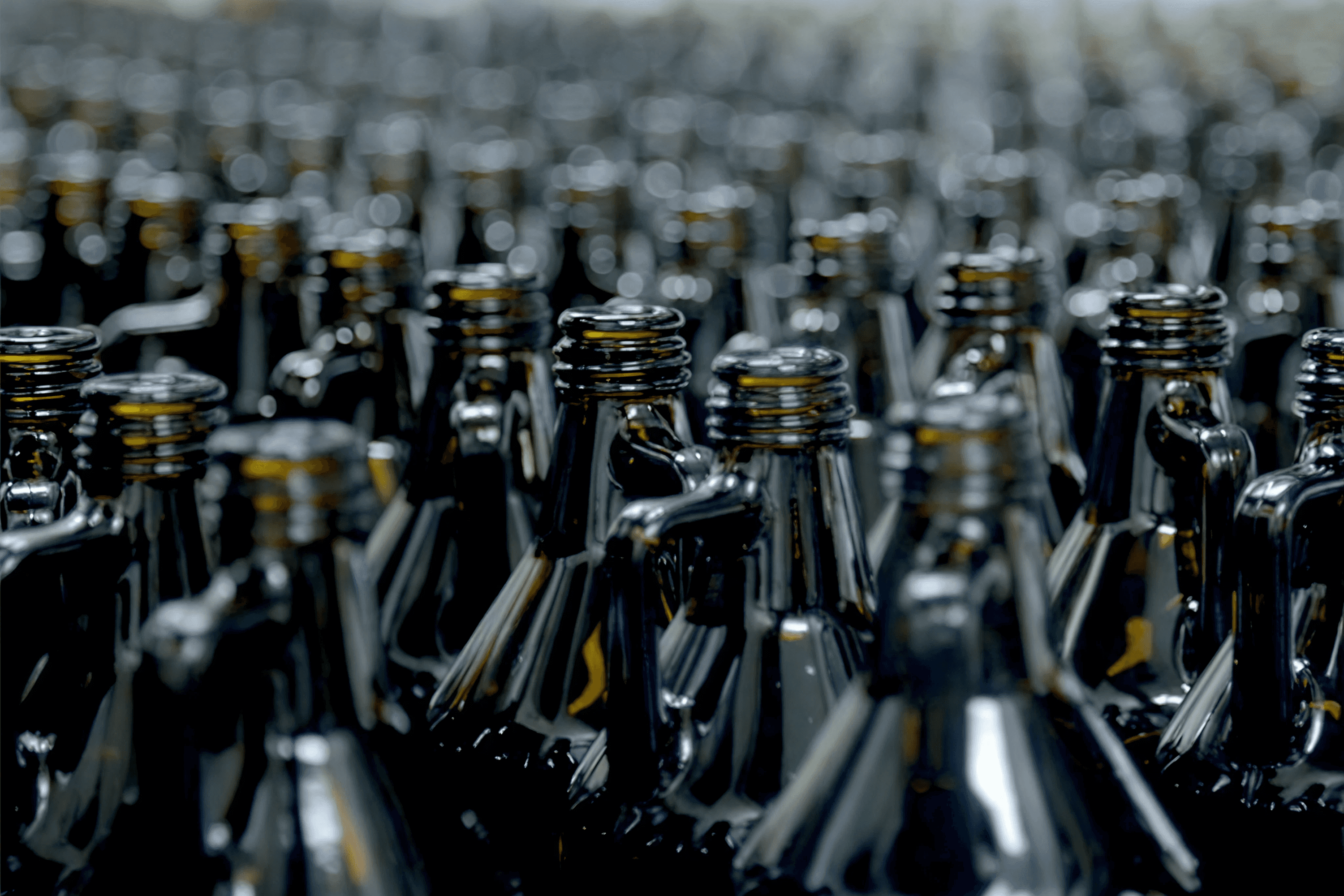 Many dark glass bottles with threaded necks.