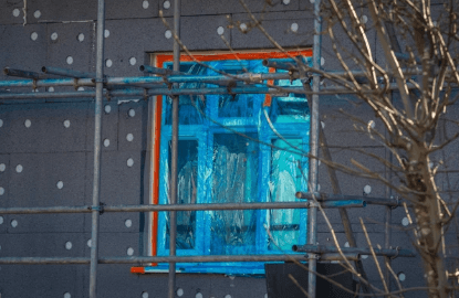 man in yellow shirt and blue denim jeans jumping on brown wooden railings under blue and