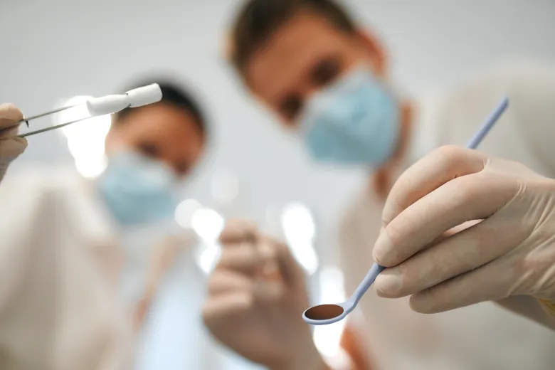 Stomatolodzy pochylający się nad pacjentem.