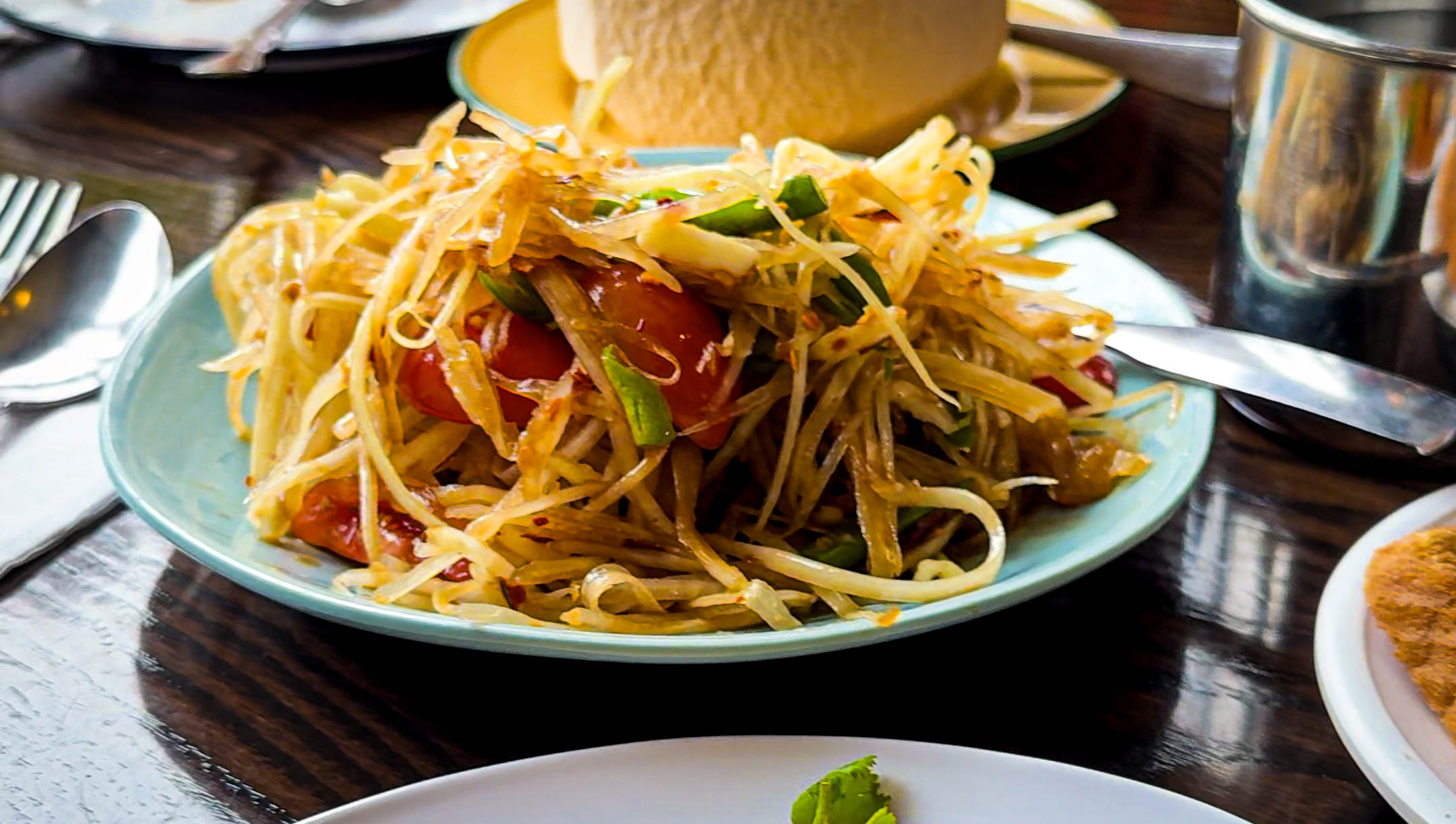 papaya salad or som tam on a wooden table at jj's thai street food