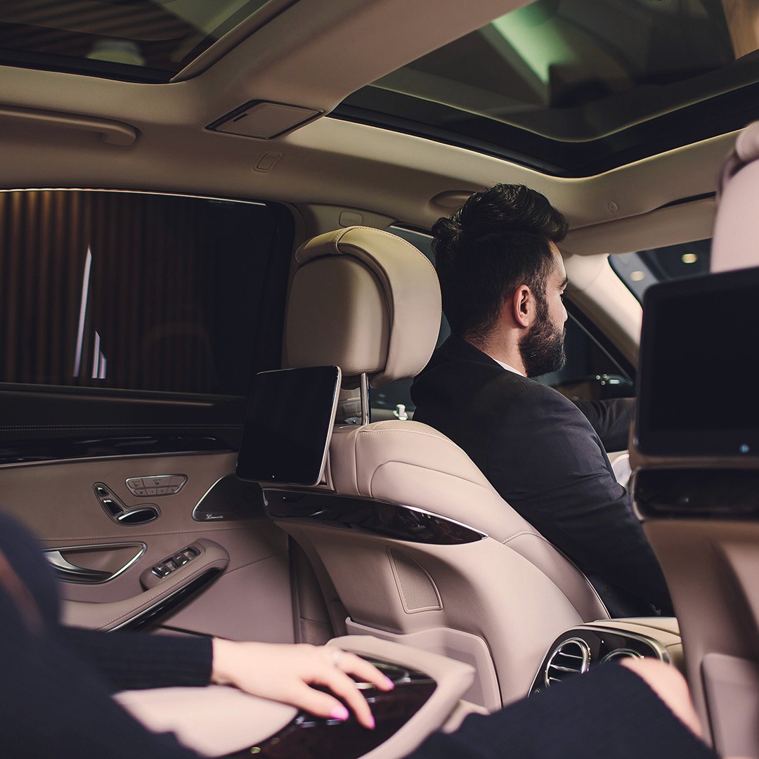 A security driver / chauffeur professional with hands on the steering wheel in a premium car