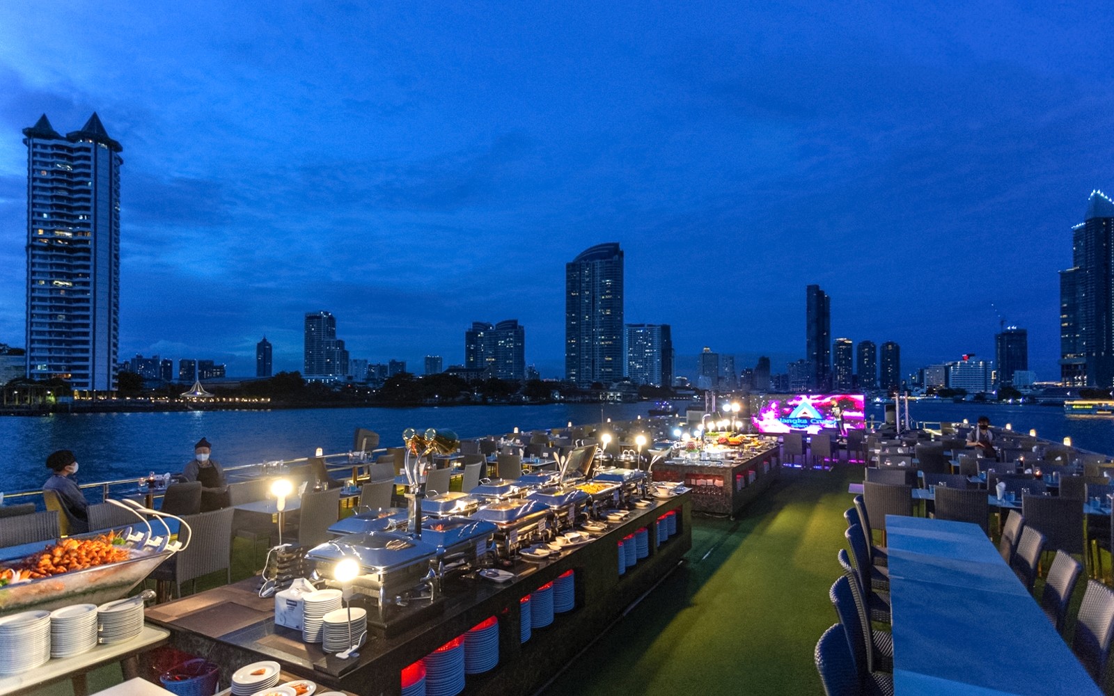 在阿兰卡晚餐巡游中享用自助晚餐，以曼谷天际线为背景。