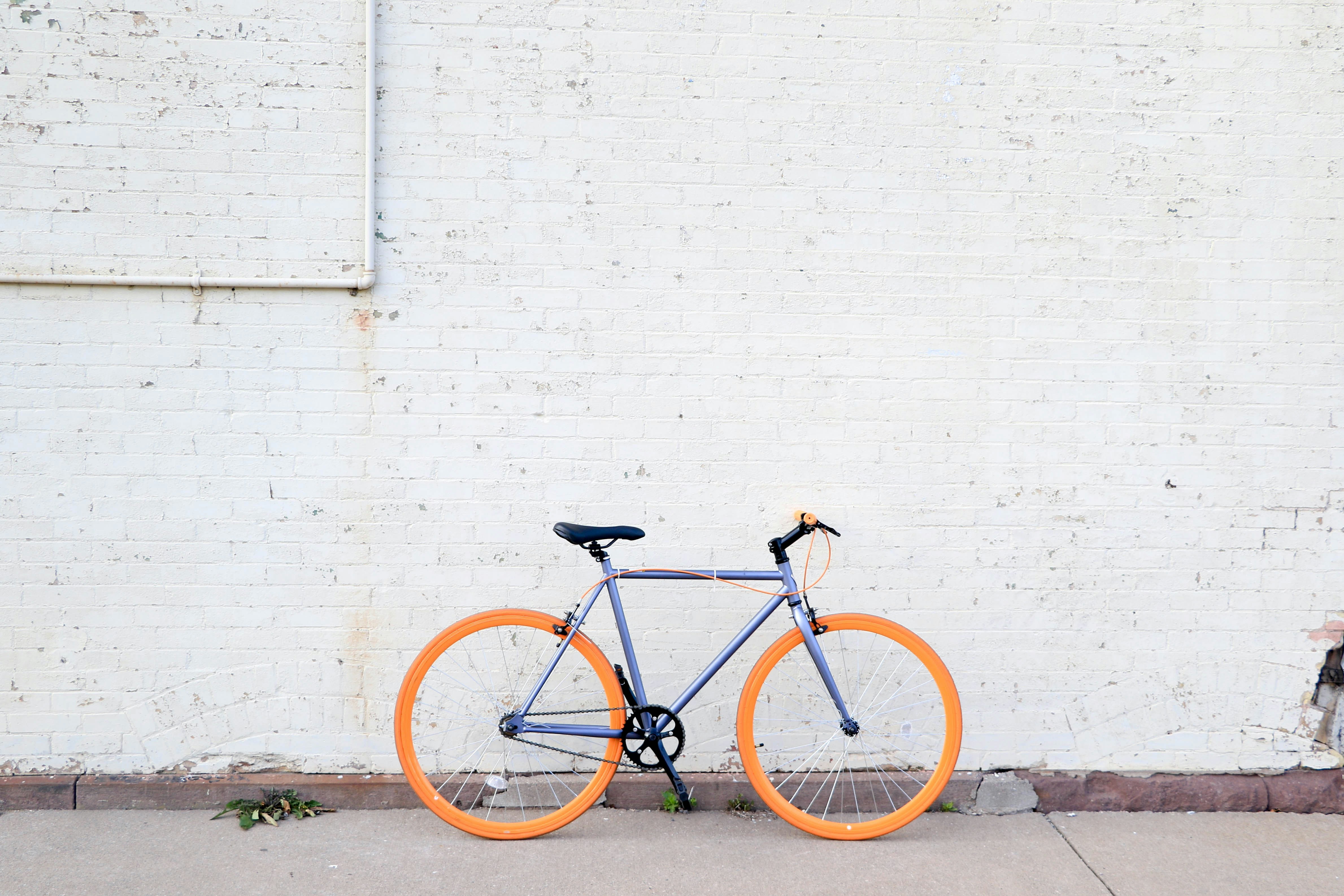 yellow and purple bicycle near white wall at daytime