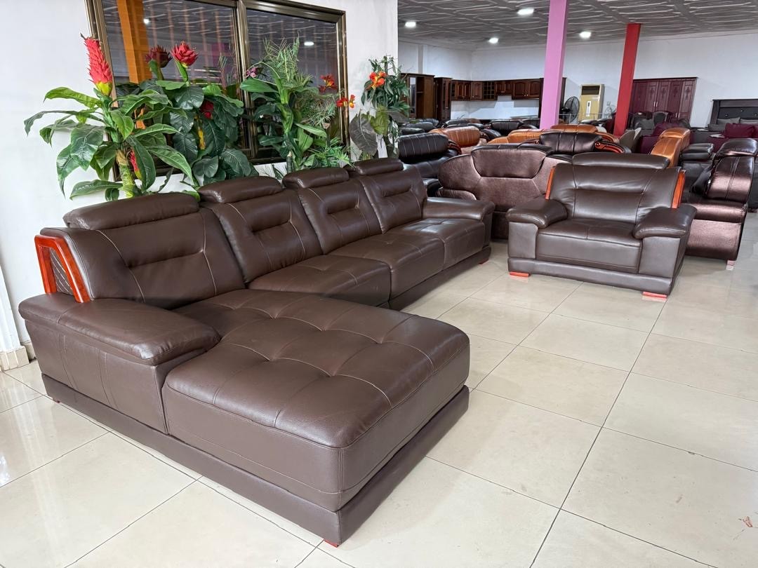 a gray couch with a wooden base on a gray background