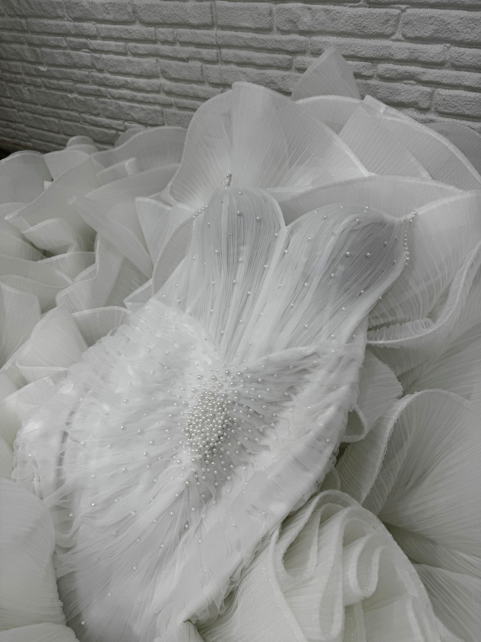 Lucidbride couture wedding gown detail with sculptural tulle, pearl embellishment and refined bridal craftsmanship.