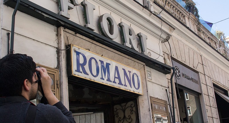 men photographing store front