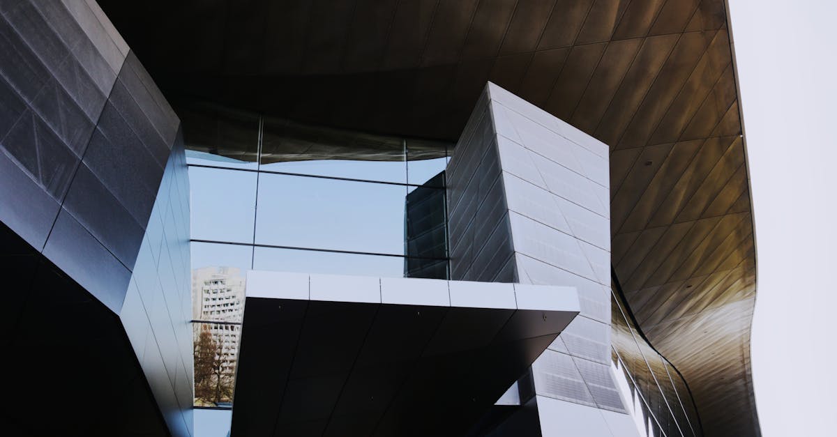Low angle shot of a modern, futuristic building with geometric glass panels in Munich.