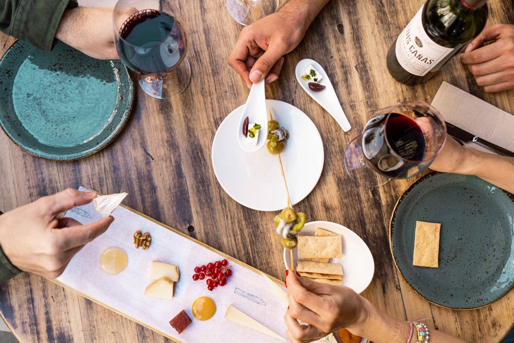 Overhead view of wine glasses and Spanish tapas pairings on a wooden table