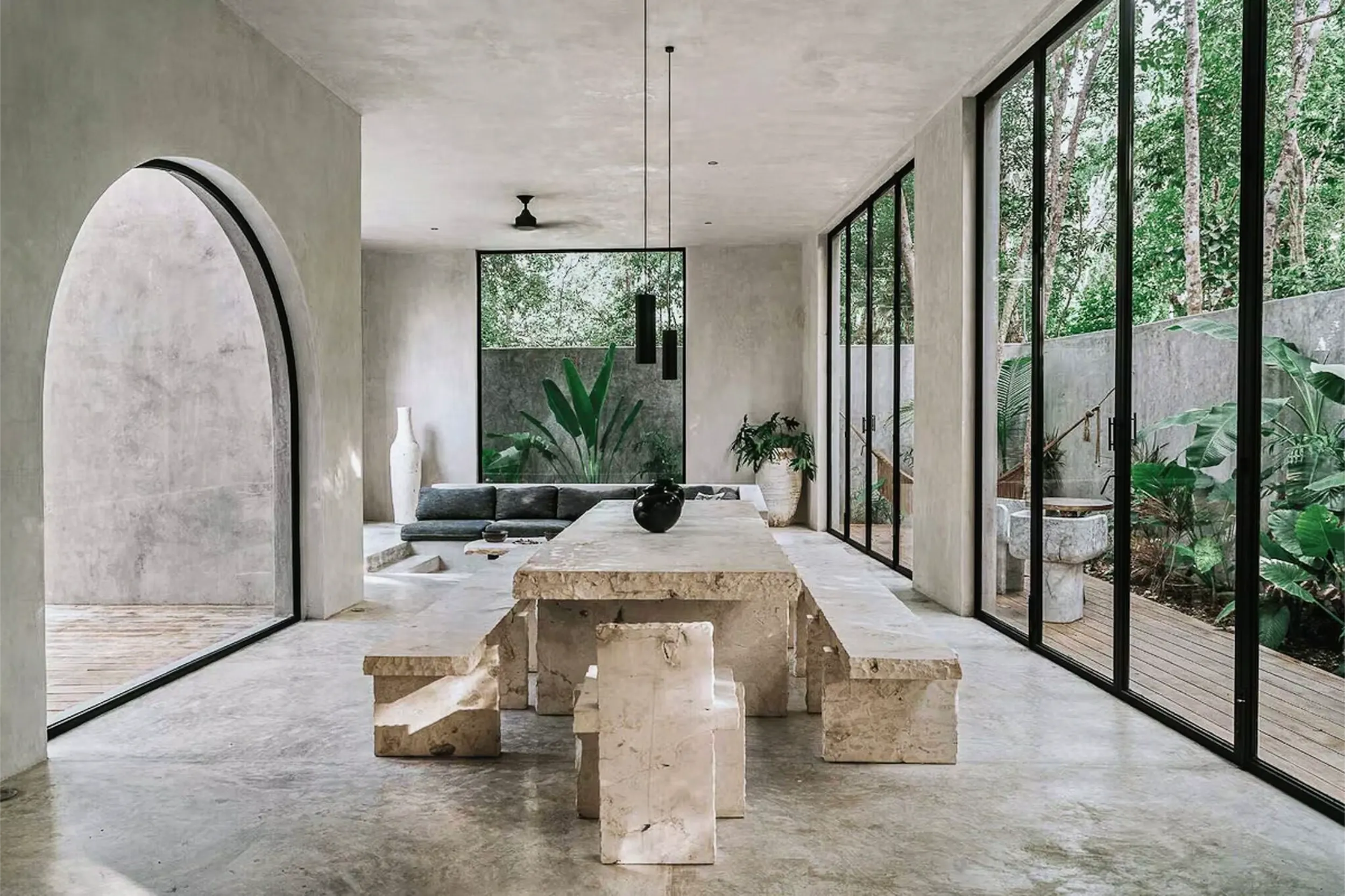 Monolithic stone dining table and concrete interiors in the modern hacienda-style residence Casa Shalva.