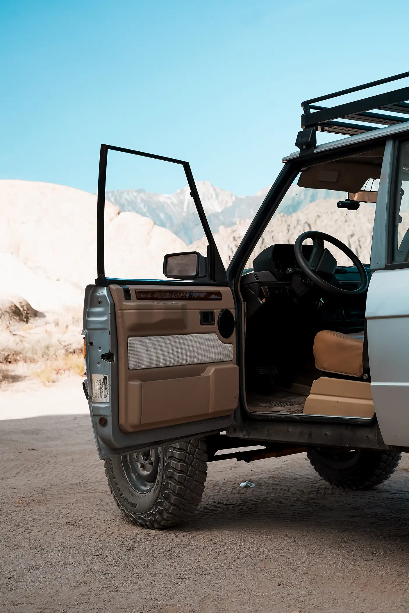 A silver Range Rover SUV with the door open, revealing the driver’s seat.