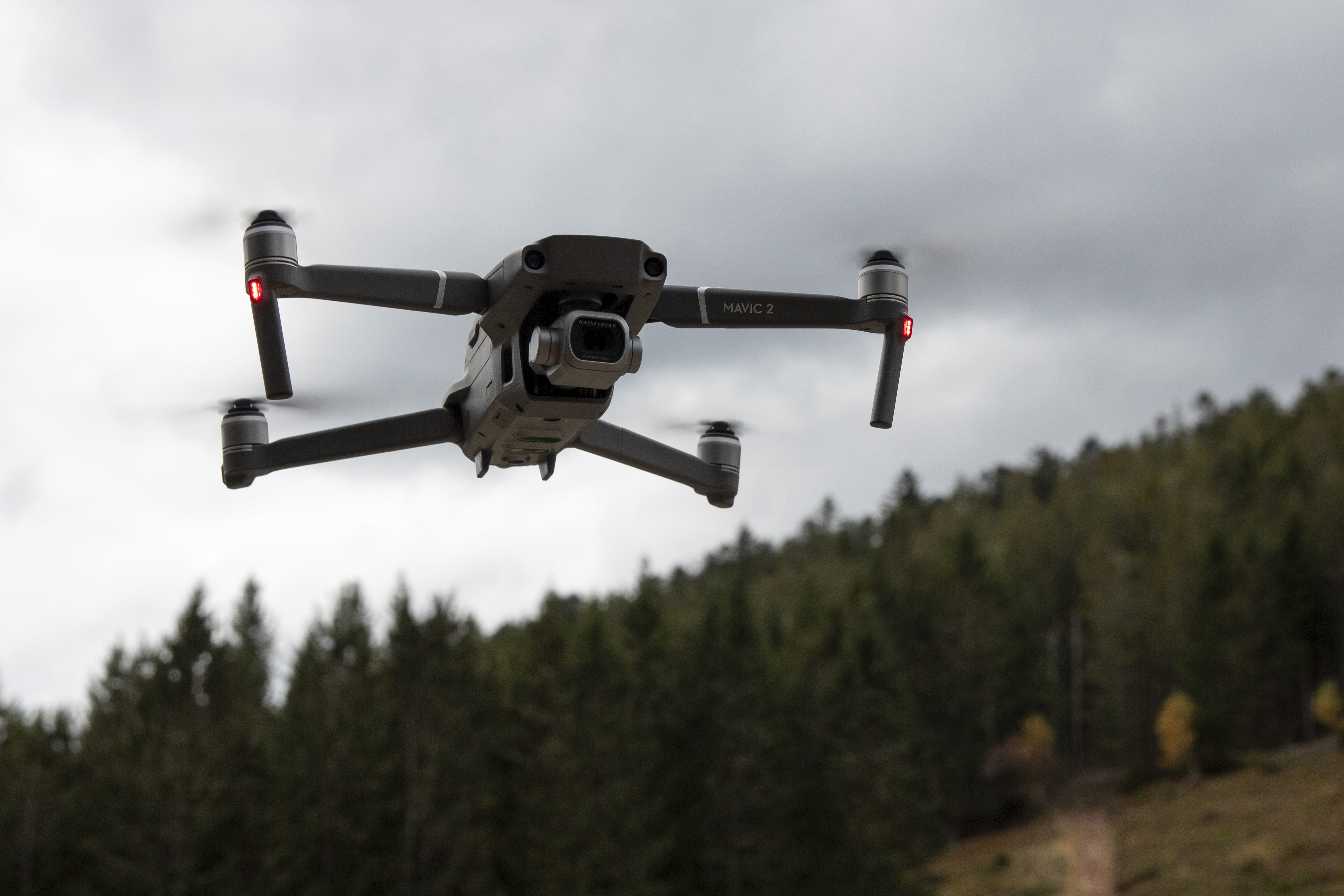 A person holding a camera is silhouetted against vivid orange stage lights. The scene conveys focus and creativity with a dramatic, moody atmosphere.